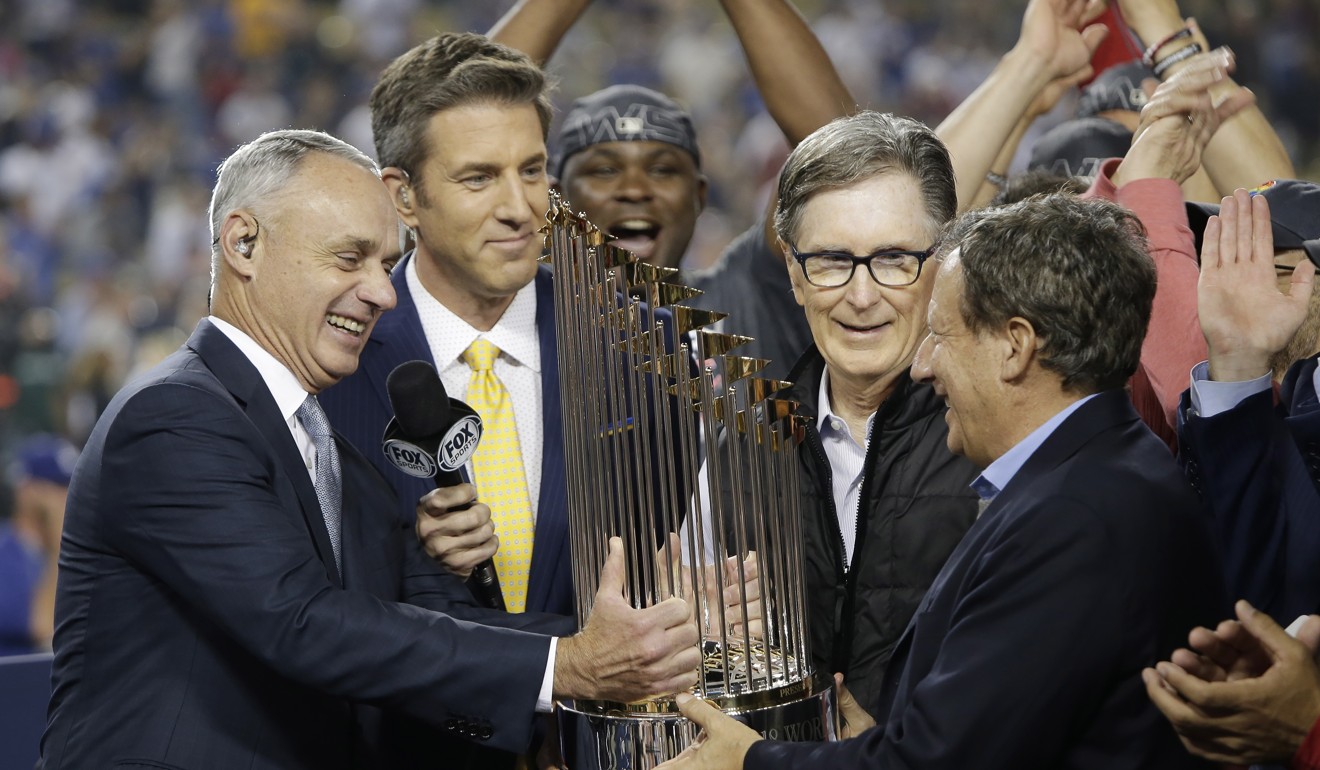 Major League Baseball Commissioner Rob Manfred (left) hands the Commissioner’s Trophy to Boston Red Sox chairman Tom Werner (right) and Boston Red Sox principal owner John Henry (second right). Photo: EPA