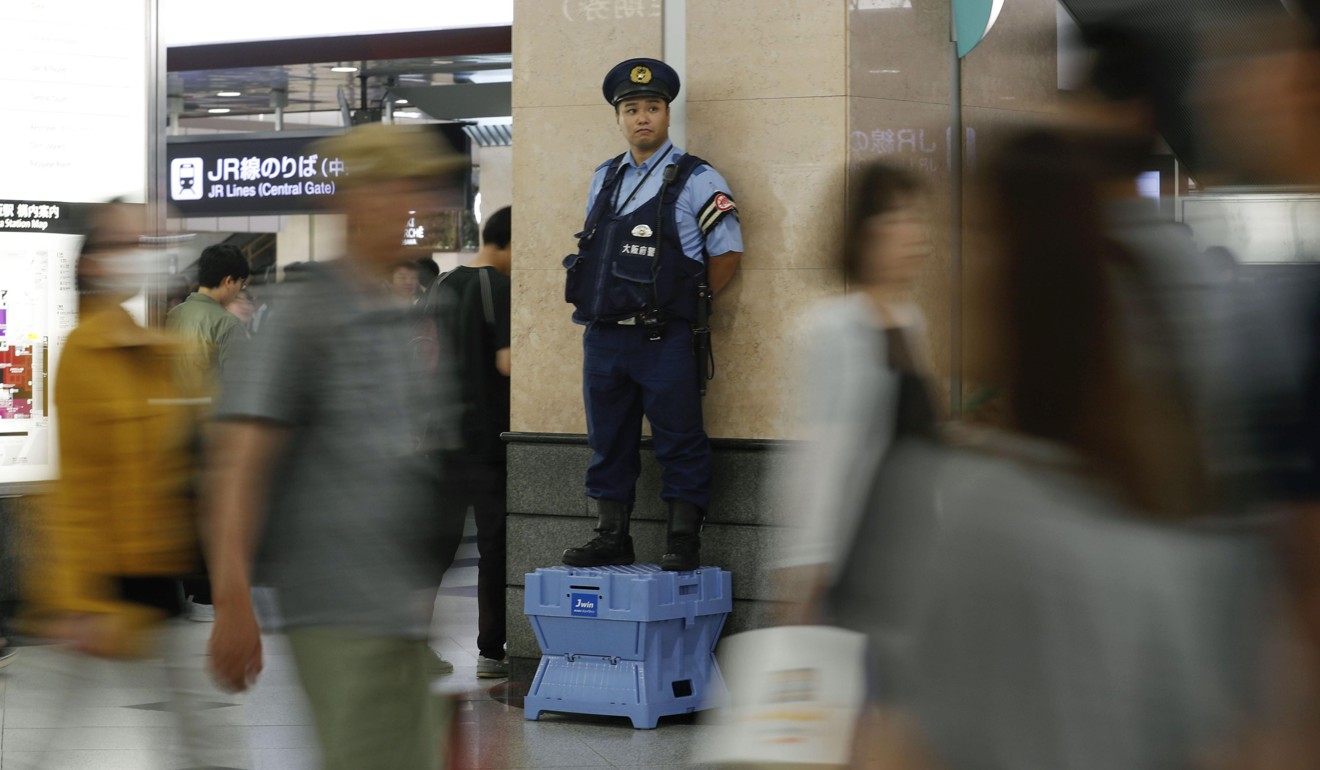 A policeman keeping an eye on commuters at JR Osaka Station. Photo: Kyodo