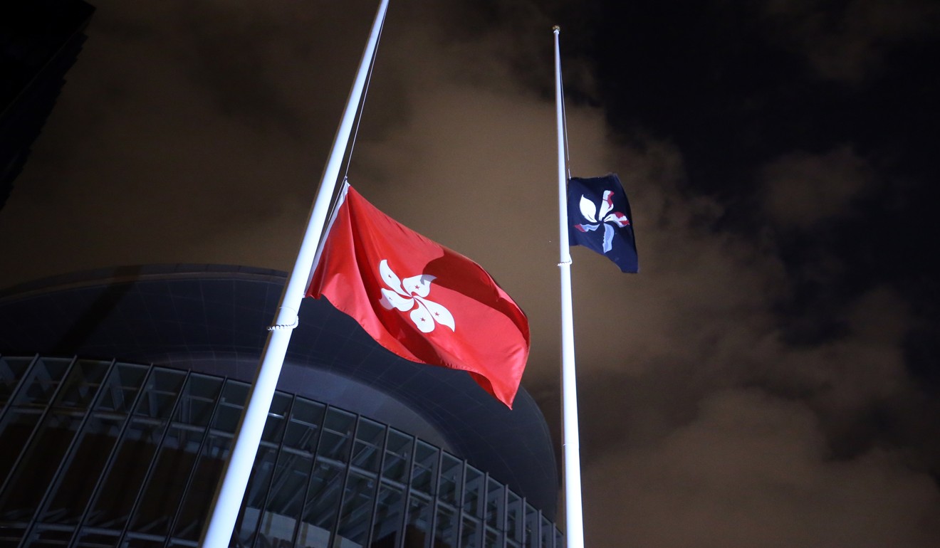 A black Hong Kong flag hoisted by protesters flies at Tamar Park in the early hours of Monday, in place of the national flag. Photo: Winson Wong