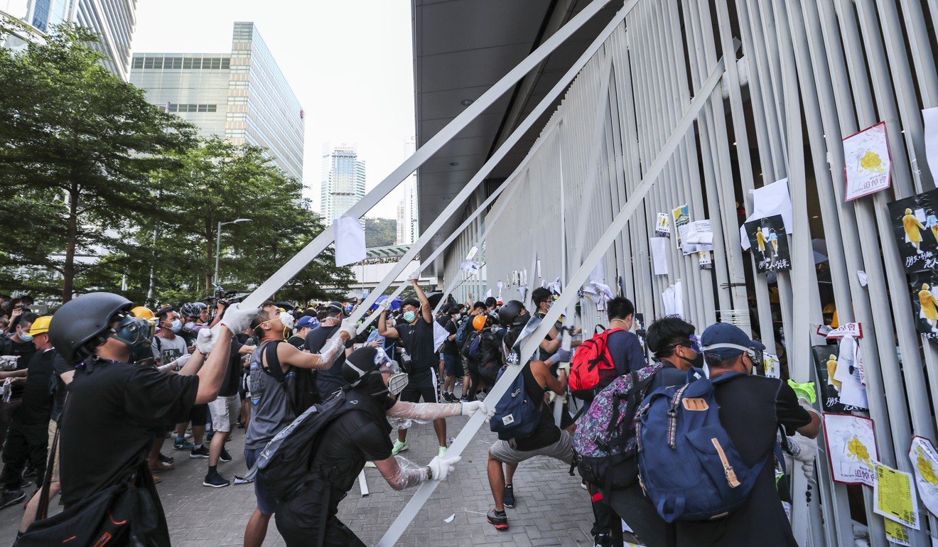 Protesters pull down metal bars on Monday in an attempt to storm the Legislative Council during a protest against the extradition bill. Photo: Sam Tsang