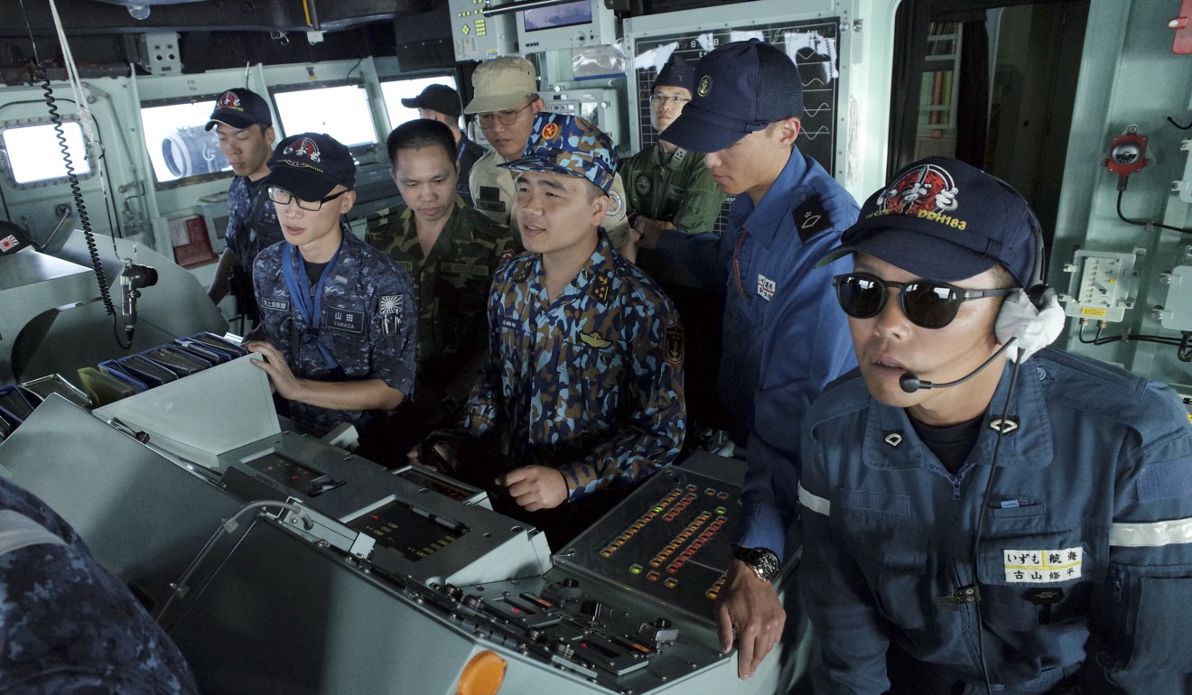 A Vietnam navy lieutenant, centre, at the helm of Izumo during a ship manoeuvring training session alongside Japanese officers. Photo: AP