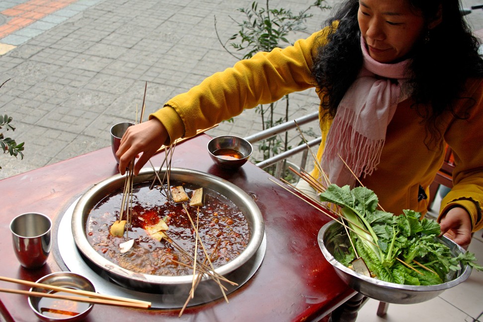 A woman tucks into a traditional spicy Sichuan meal. Photo: Alamy