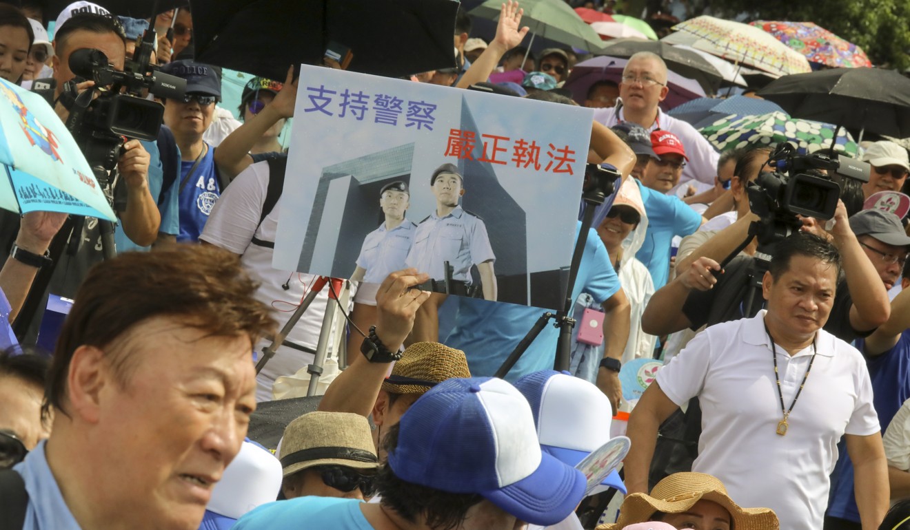 Attendees hold up images of Hong Kong officers in support of police and their response to the extradition bill demonstrations. Photo: K.Y. Cheng