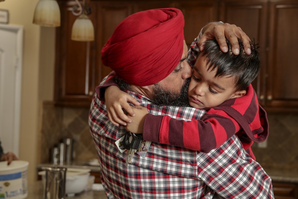 Singh comforting his four-year-old son Devjot Kamboj, who was saddened after hearing that his father is going to leave early the next morning for a week-long trip to Indiana. Photo: TNS