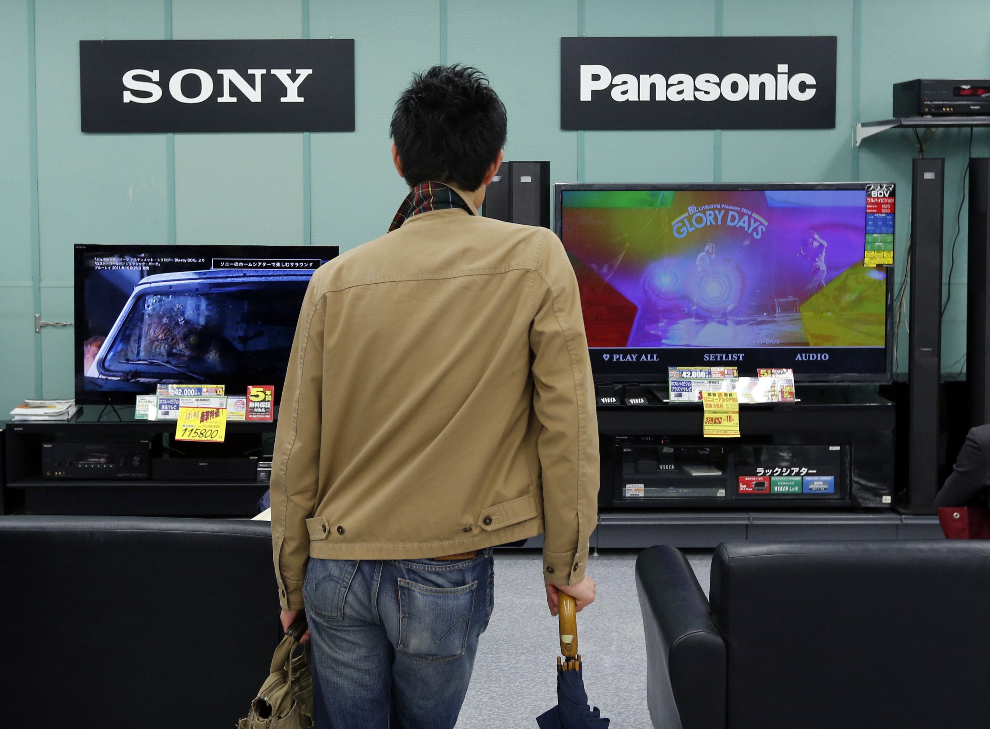 A man looks at Sony and Panasonic TV sets. Photo: Reuters