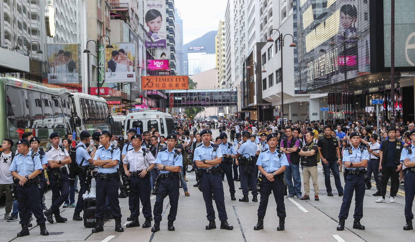 Police officers watch as people take part in an anti-extradition bill march from Tsim Sha Tsui to West Kowloon station. Photo: Sam Tsang
