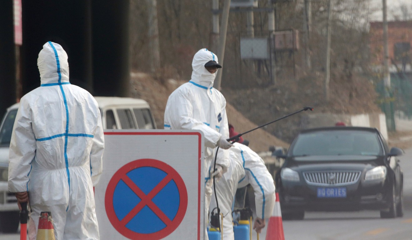 Workers in protective suits at a checkpoint near a farm where African swine fever was detected in the Fangshan district of Beijing. Photo: Reuters