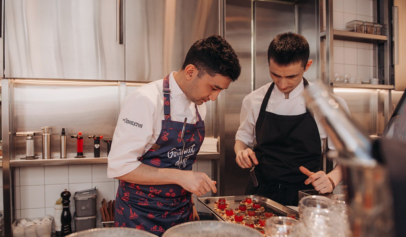 Hezret-Arslan Berdiev (left) preparing a tomato dish.