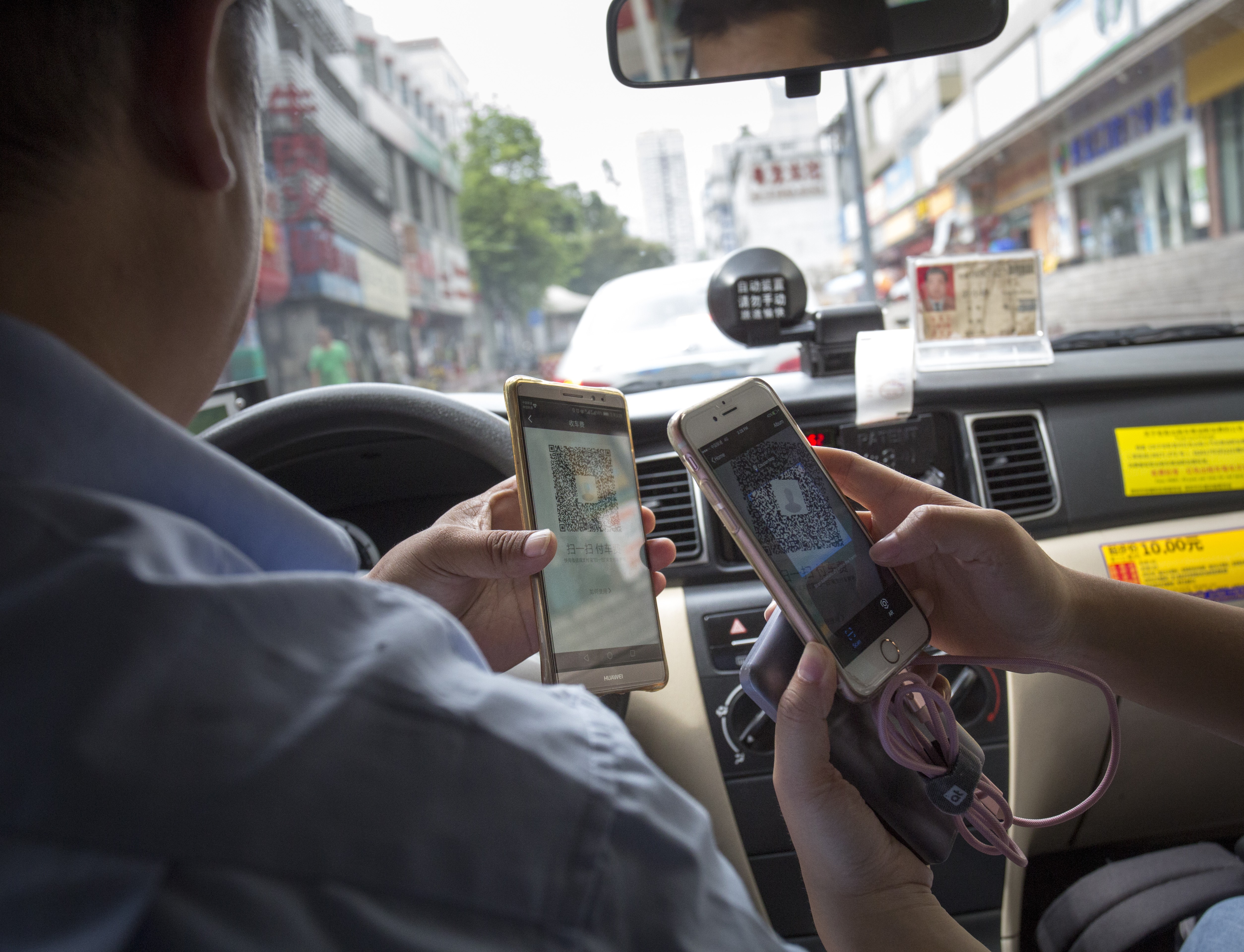 A passenger pays for her ride via mobile payment in Shenzhen. Photo: May Tse