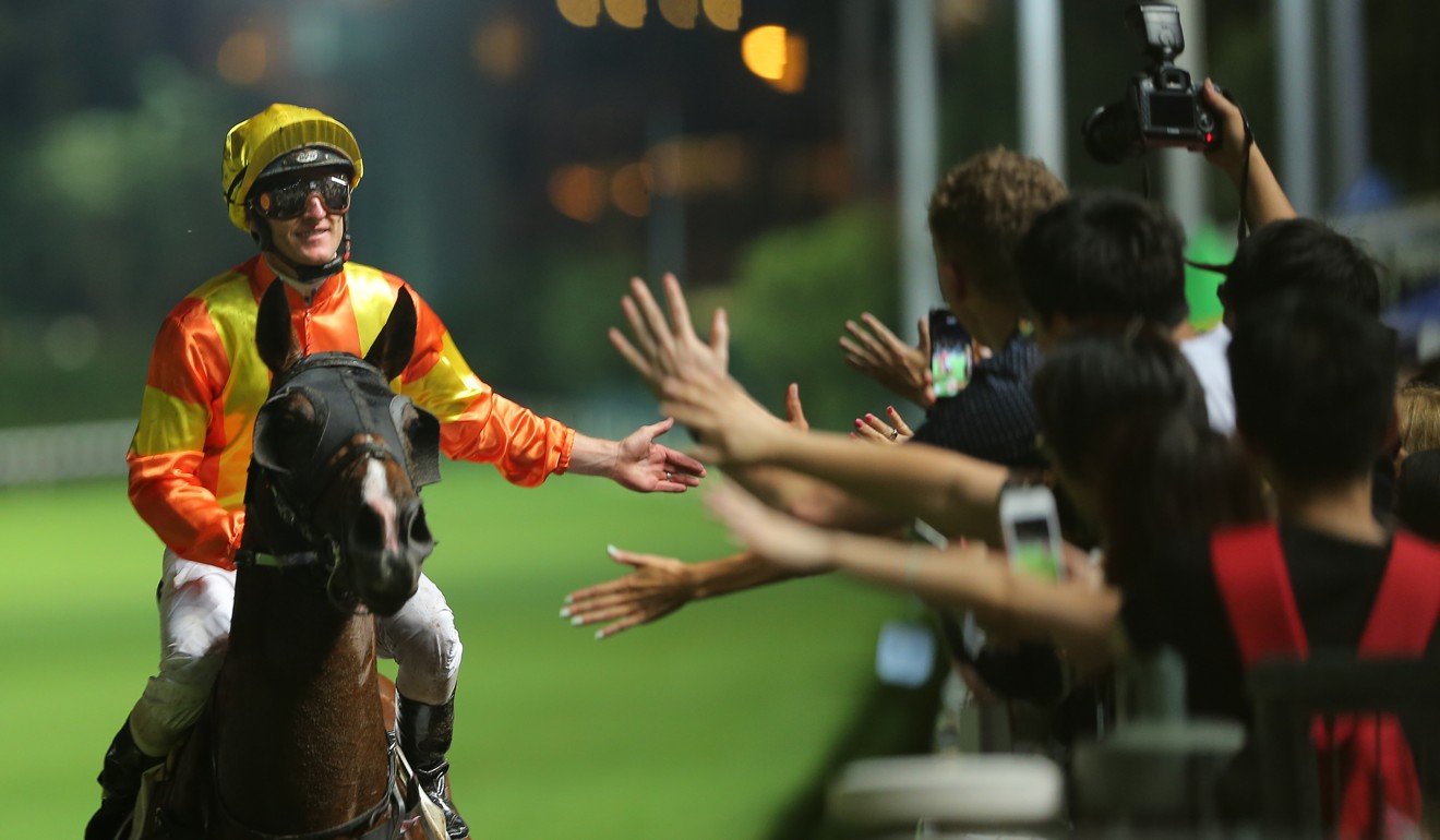 Zac Purton high-fives the fans after winning with High Rev on Wednesday night.