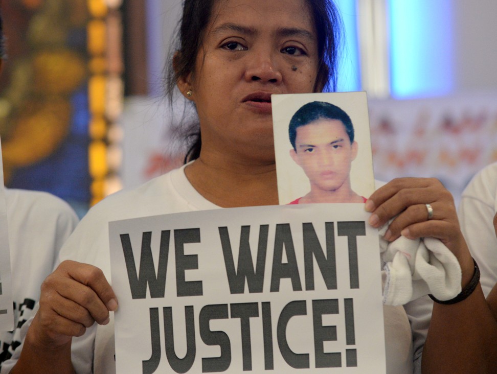 A woman holds up a photo of her son, a drug war victim. Photo: Reuters