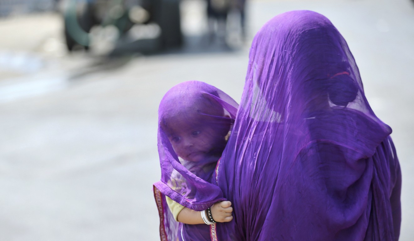 An Indian woman carries a child on a hot summer’s day in Hyderabad. Photo: AP