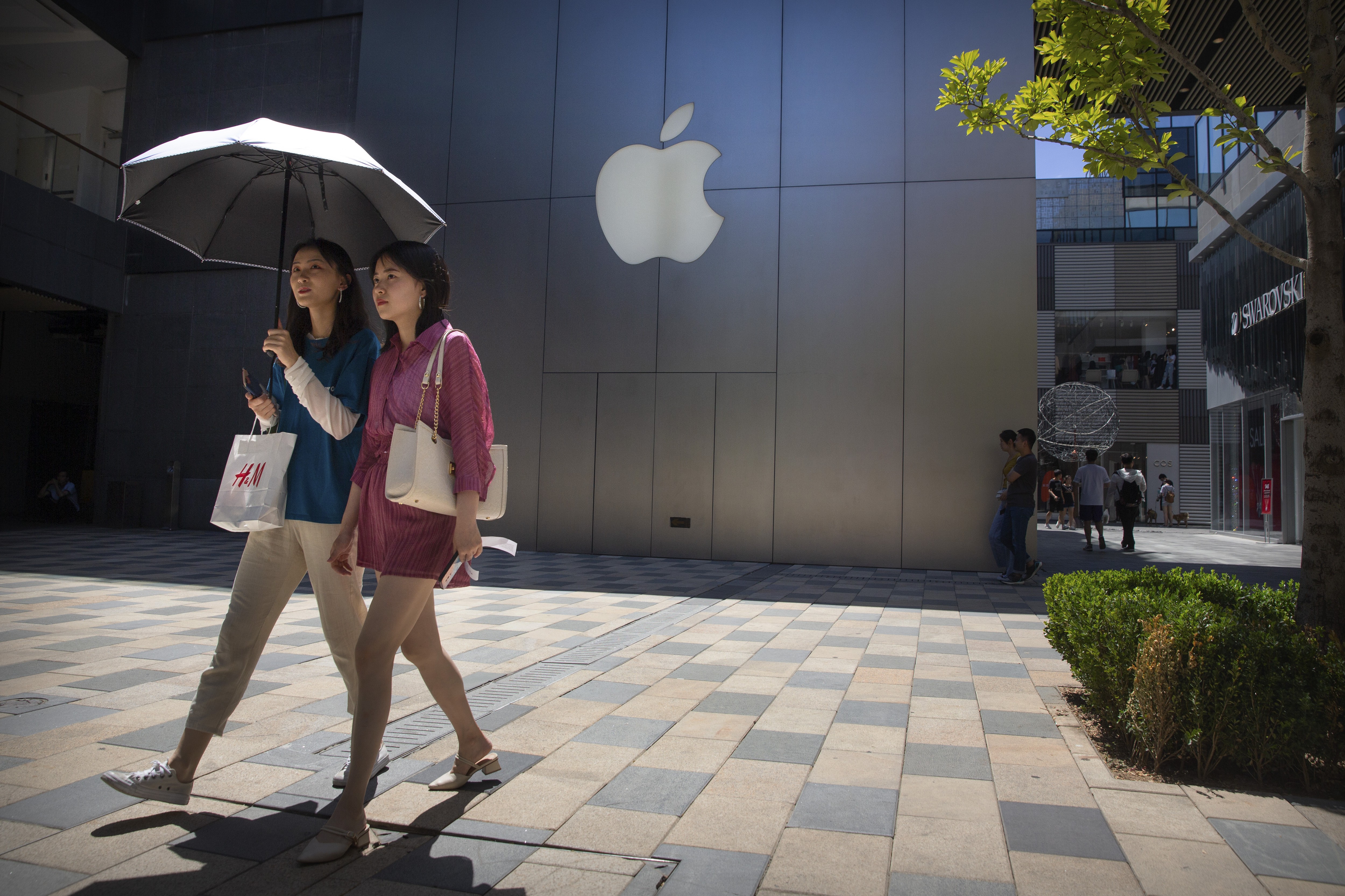 People walk past an Apple store in Beijing. Presidents Donald Trump and Xi Jinping have agreed to a new truce in a year-long trade war between the US and China. Photo: AP