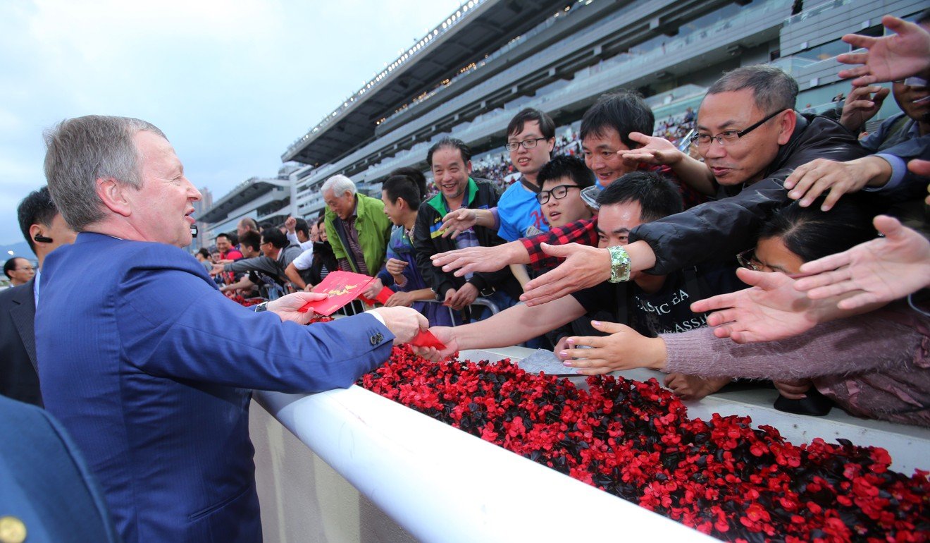 Jockey Club chief executive Winfried Engelbrecht-Bresges hands out red packets to punters.