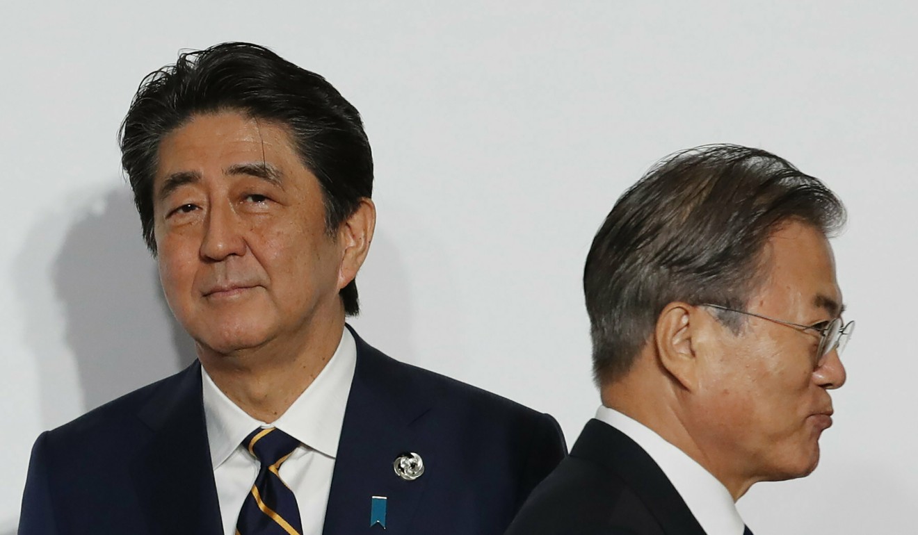 South Korean President Moon Jae-in walks by Japanese Prime Minister Shinzo Abe at last month’s G20 summit in Osaka, Japan. Photo: AP