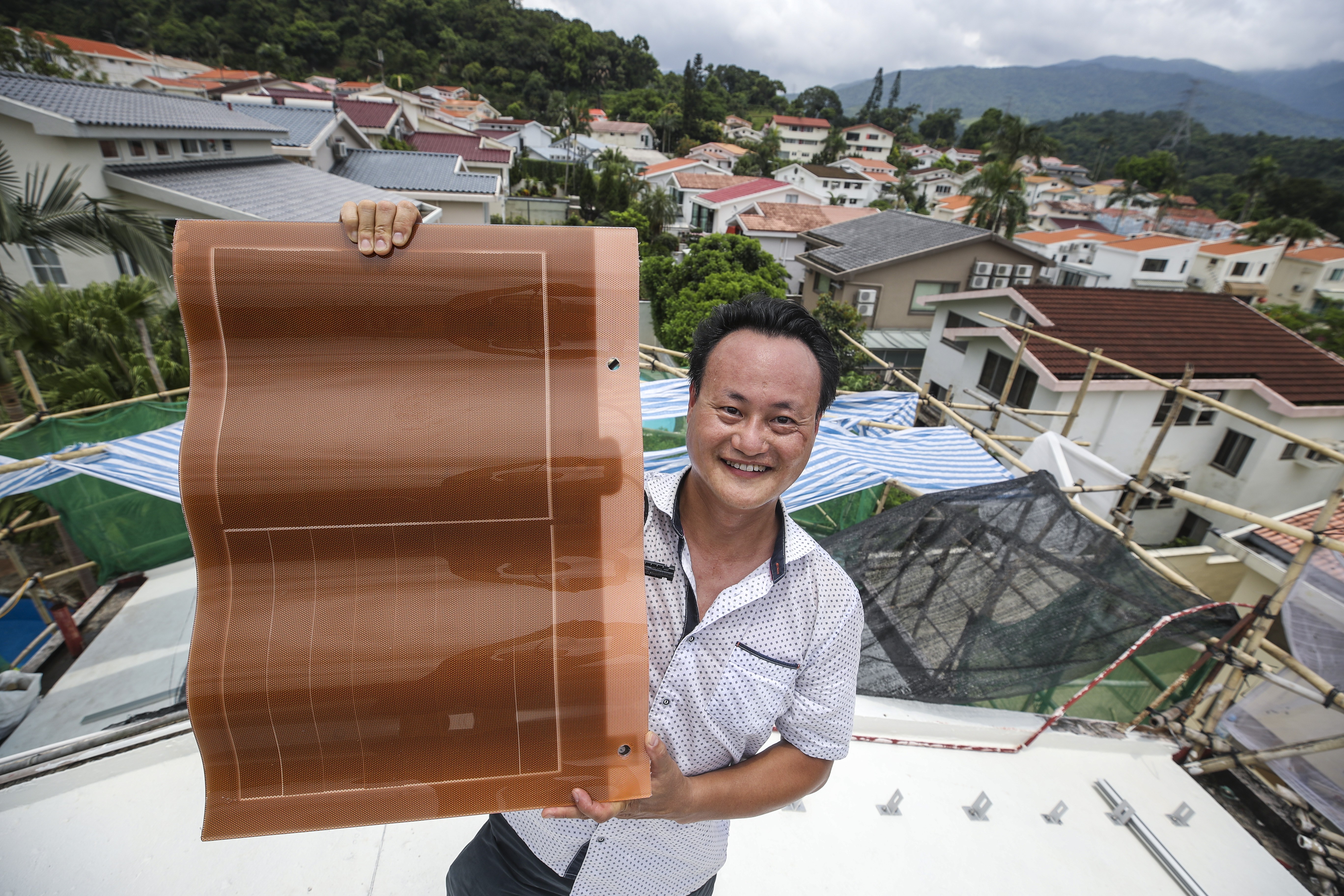 Mondo Ching, chairman of Mondo Green Energy, with a rooftop solar component in Tai Po on July 11. Photo: Winson Wong