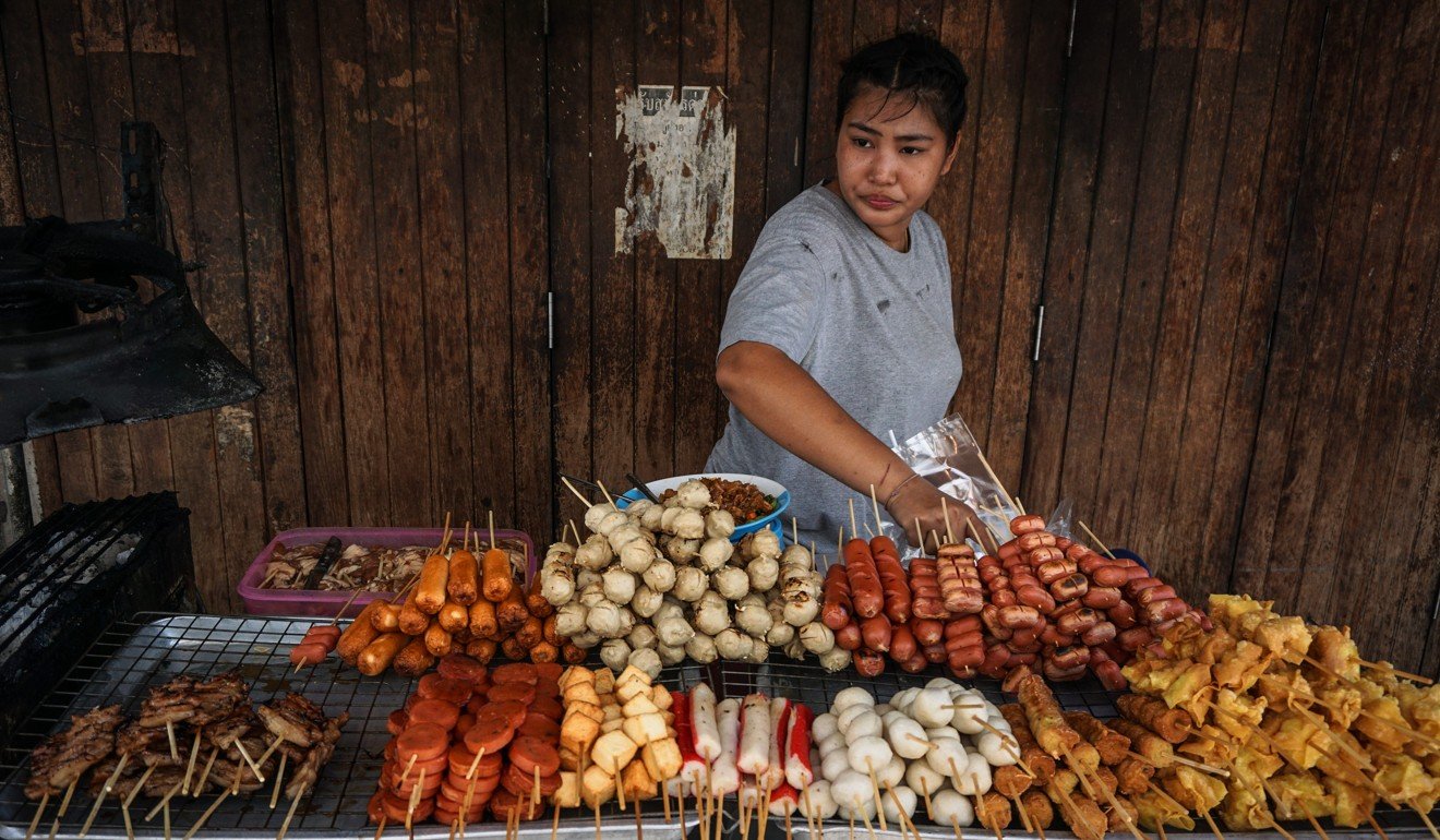 A stallholder tends to her food cart in the Pratunam district of Bangkok. Photo: AFP