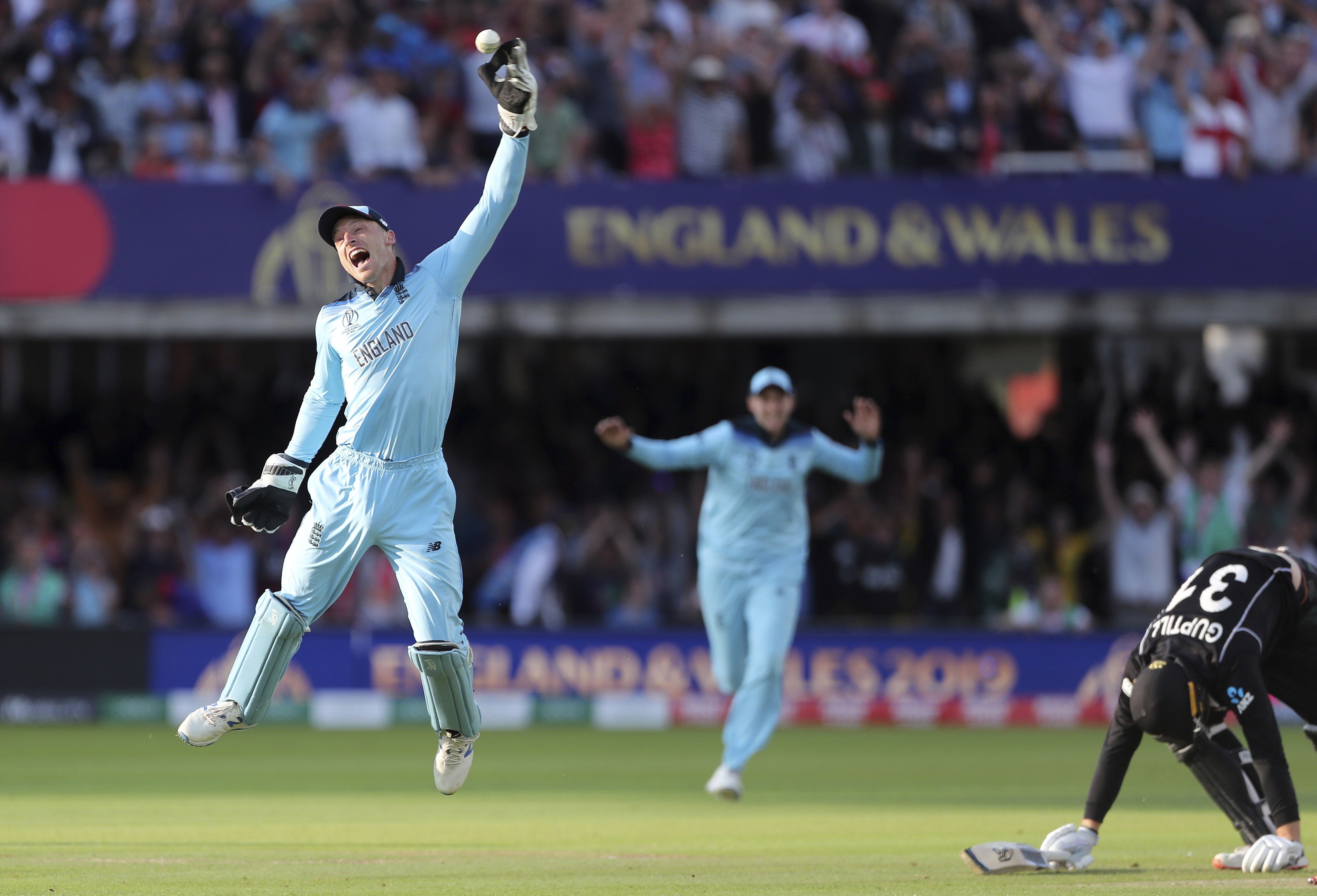 England’s Jos Buttler celebrates after running out New Zealand’s Martin Guptill, right, with the last ball of the last over of the Cricket World Cup final. Photo: AP