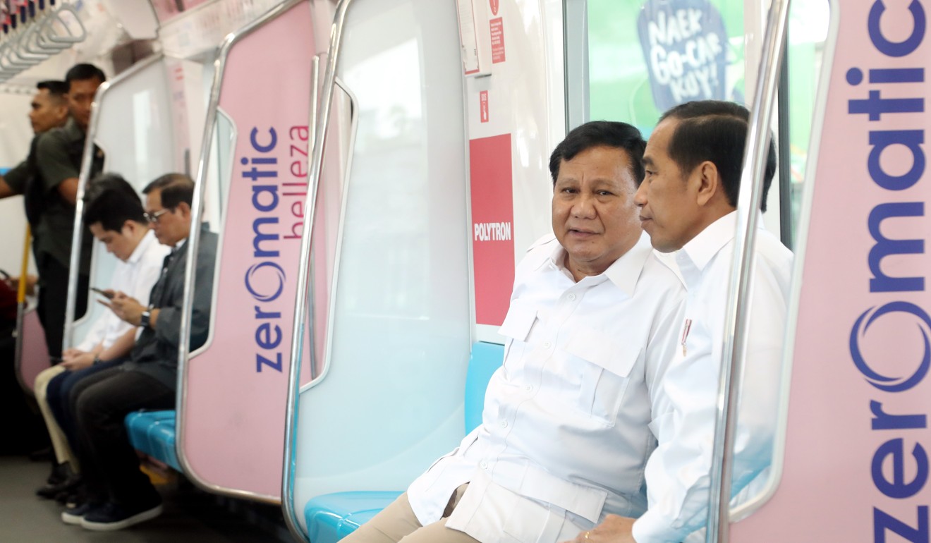 Prabowo Subianto sits with Indonesian President Joko Widodo on the subway. Photo: EPA