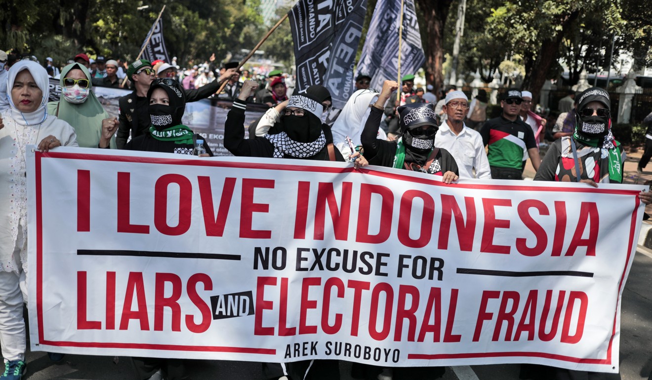 Supporters of Indonesian presidential candidate Prabowo Subianto display a banner during a protest against the results of April's presidential election, Photo: AP
