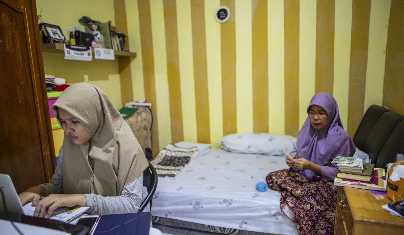 Rizka at work in a room with her mother. Photo: Unicef/Arimacs Wilander