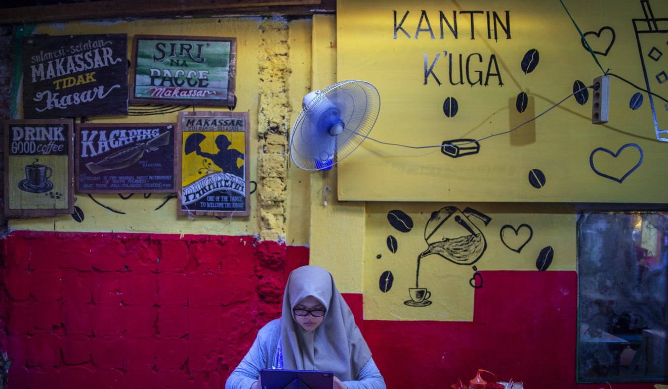 Rizka working on comics in the canteen, her favourite place to draw at school. Photo: Unicef/Arimacs Wilander