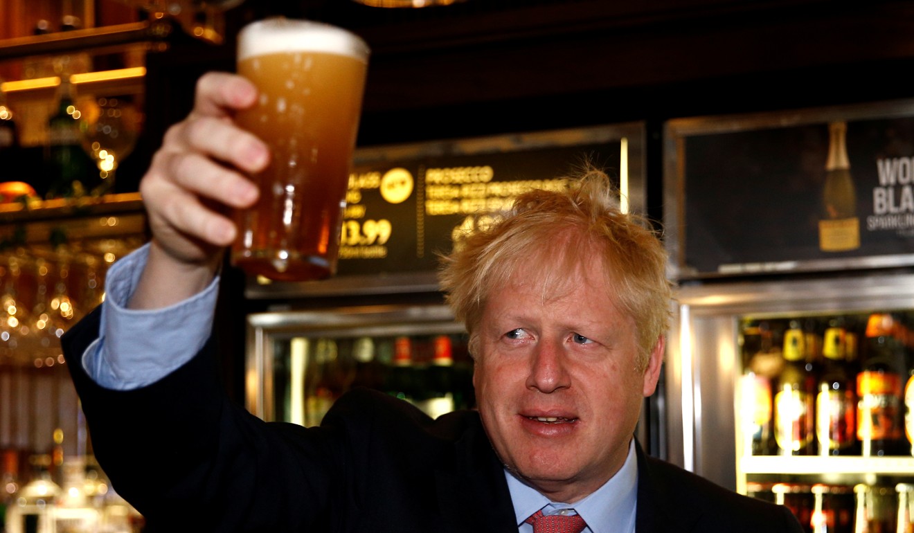 Boris Johnson raises a pint of beer while campaigning. Photo: Bloomberg