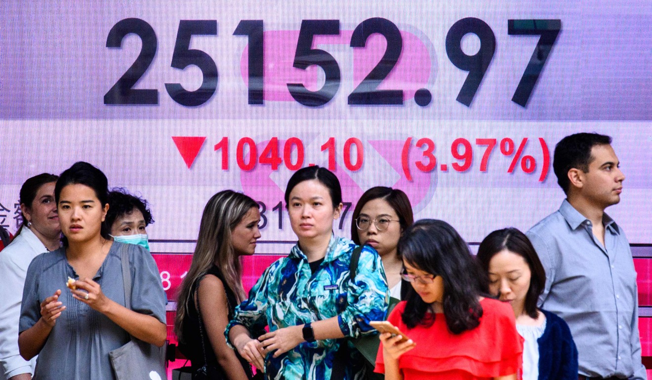 Pedestrians stand in front of an electronic display board showing the Hang Seng Index on October 11, 2018. International investors trust Hong Kong’s strong financial regulatory regime. Photo: AFP