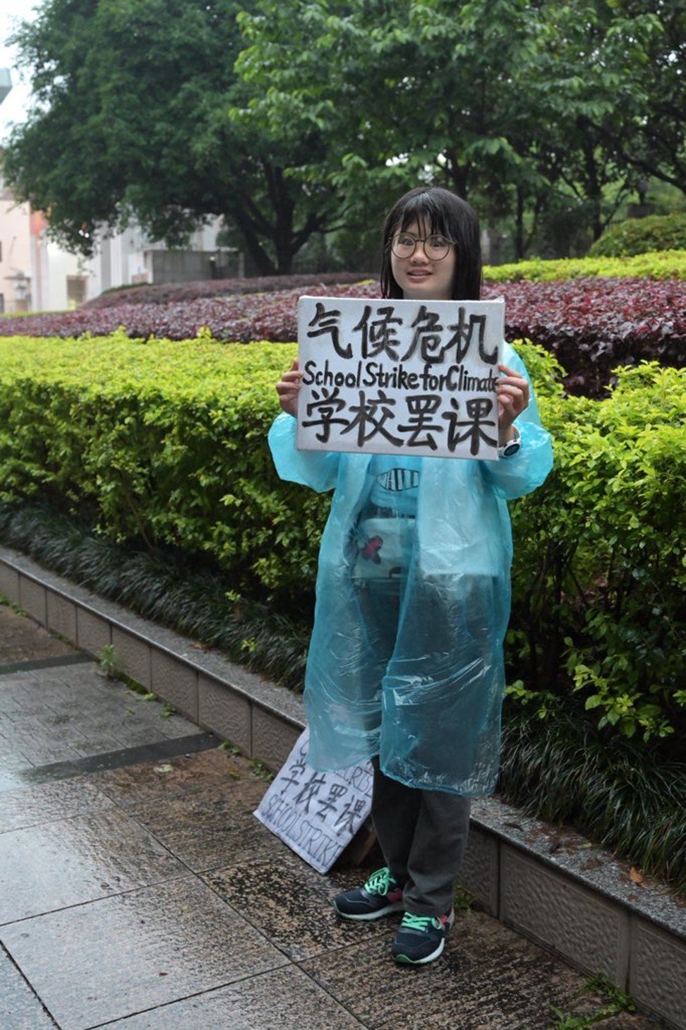 Howey Ou standing alone outside the Guilin People’s Government building in a climate-change protest.