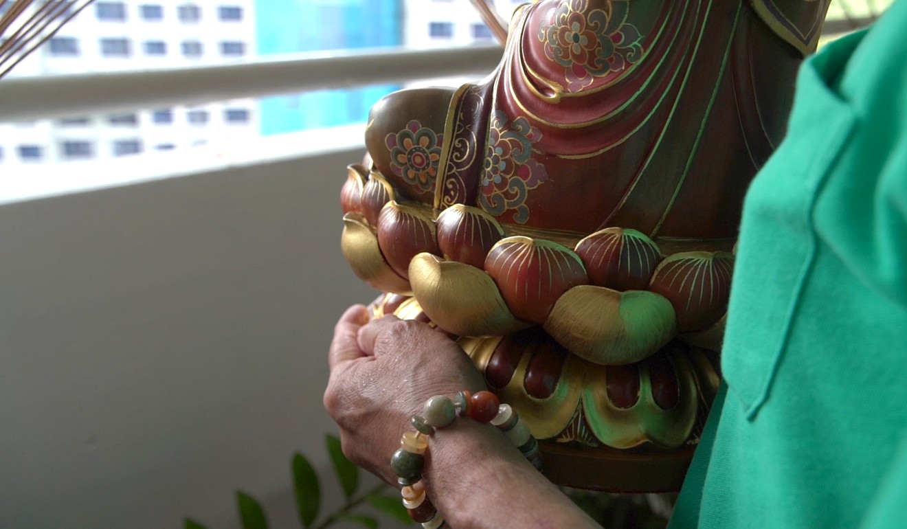 A client who wanted his house to be cleansed of negative energy holding a statue of Bodhisattva. Photo: Dayu Zhang