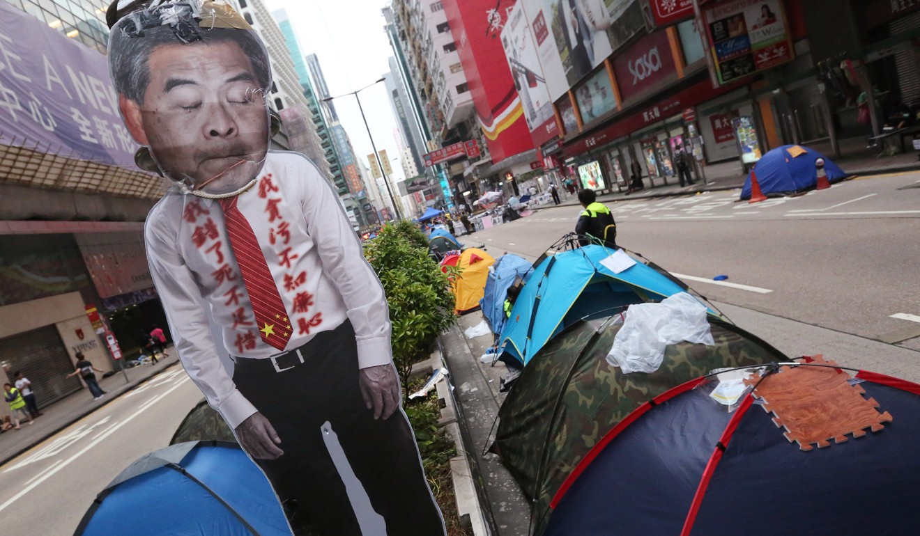 Protesters along the streets in Hong Kong on 2014, with a sign showing the face of then city leader CY Leung. Photo: Felix Wong