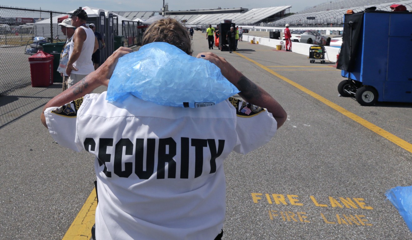A racetrack security guard carries a bag of ice to cool down at the New Hampshire Motor Speedway in Loudon on Friday. Photo: AP