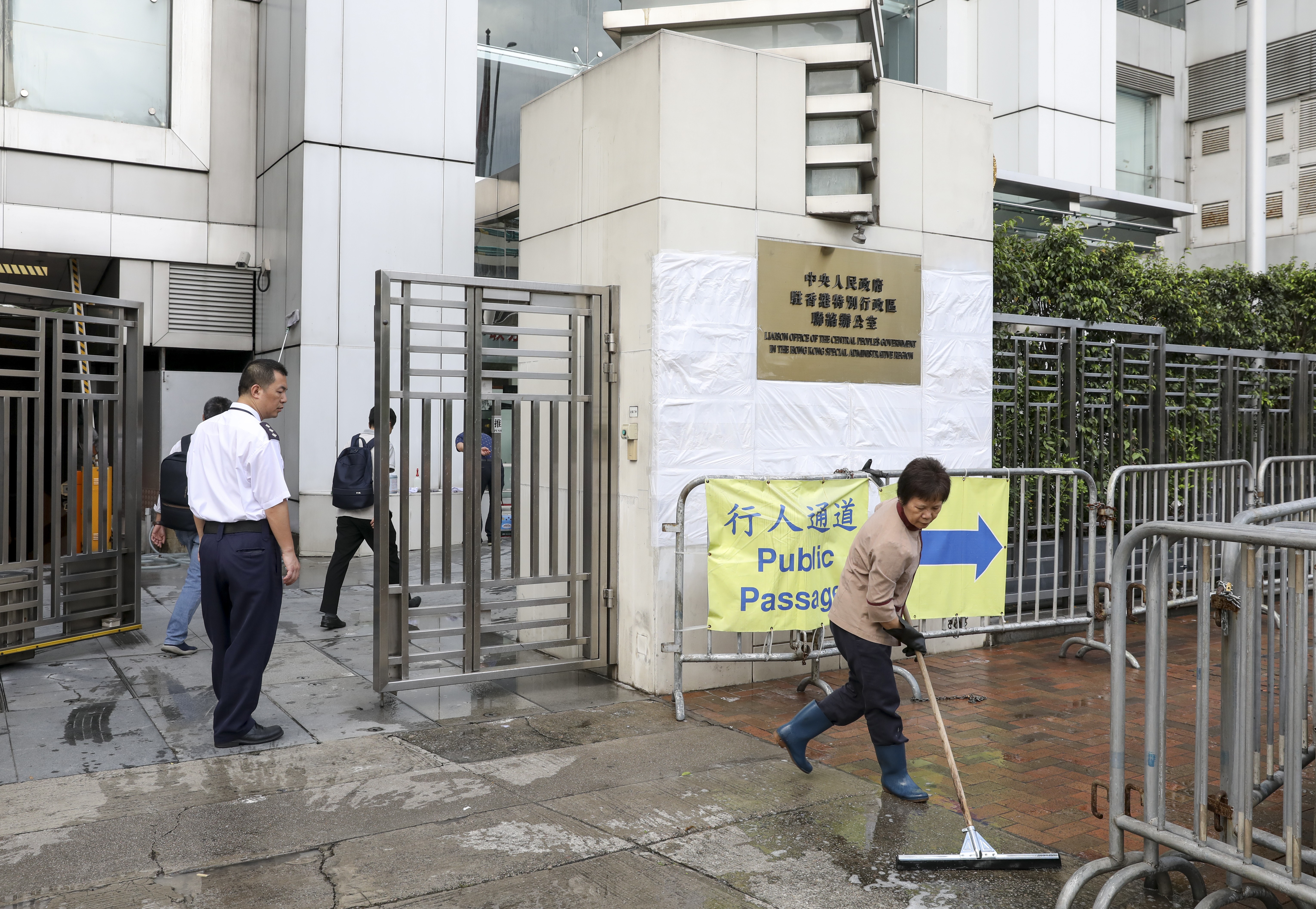 A worker continues to clean-up the mess left by protesters outside the liaison office in Sai Ying Pun. Photo: Nora Tam
