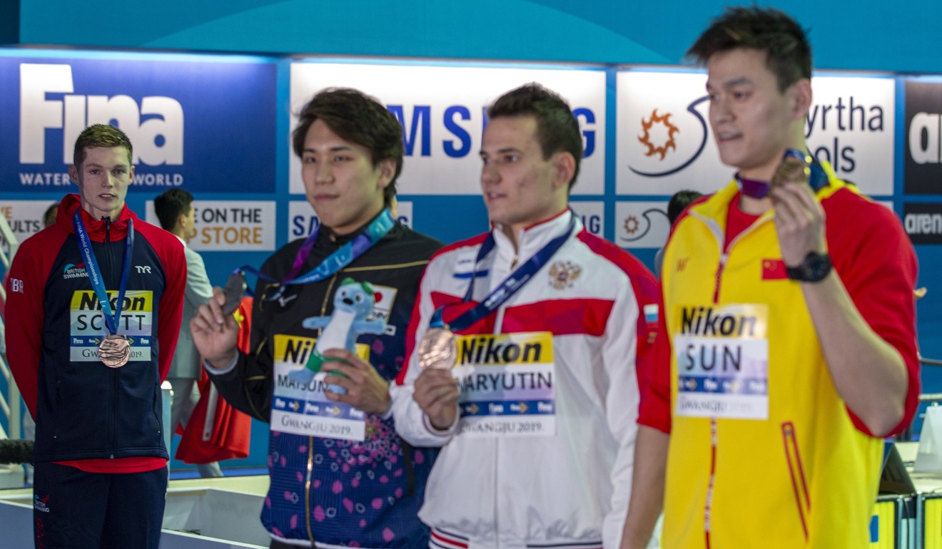Sun Yang, silver medallist Katsuhiro Matsumoto (left) of Japan and joint bronze medal winner Martin Malyutin of Russia take pictures on the podium while Duncan Scott stands to the right. Photo: EPA