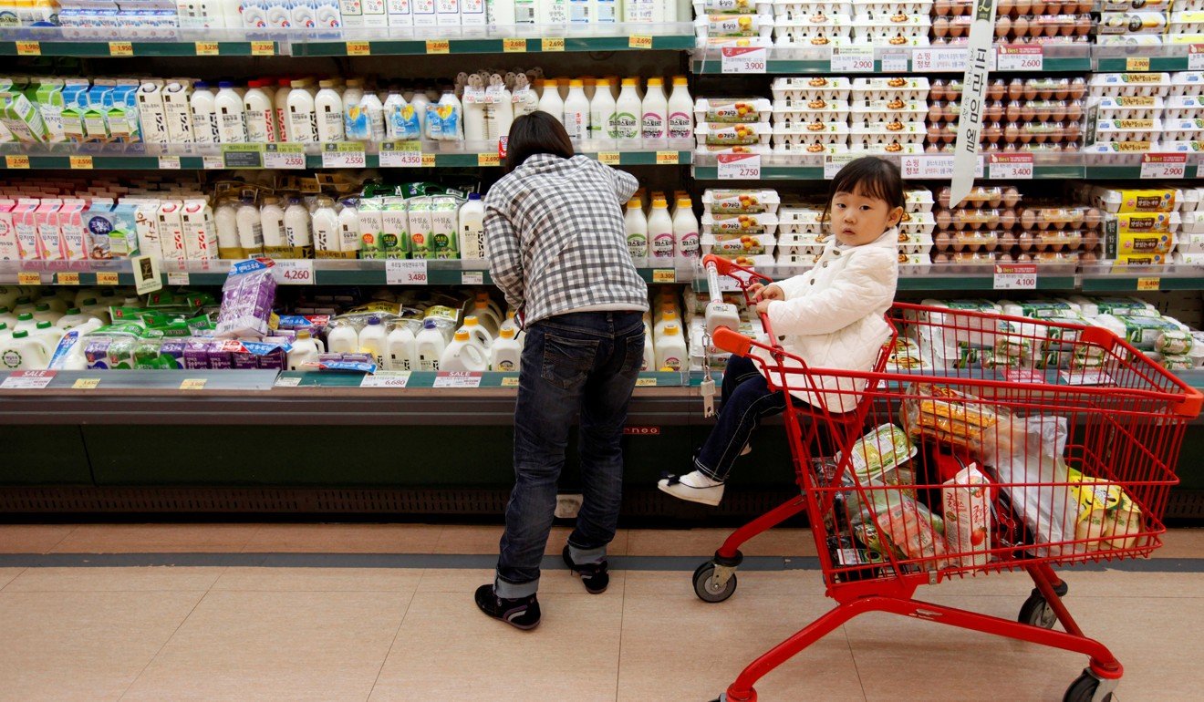A mum shops at a supermarket with her child in Seoul. Photo: Reuters