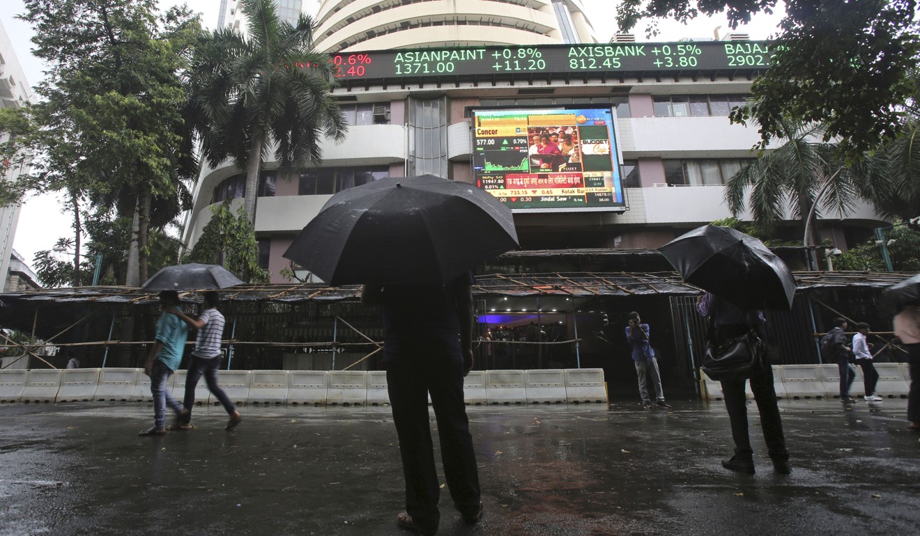 Indians watch the stock market index on a display screen on the facade of the Bombay Stock Exchange building in Mumbai, India, on July 5. Indian Prime Minister Narendra Modi's government has proposed to invest heavily in infrastructure, the digital economy and job creation to lift the economy. Photo: AP