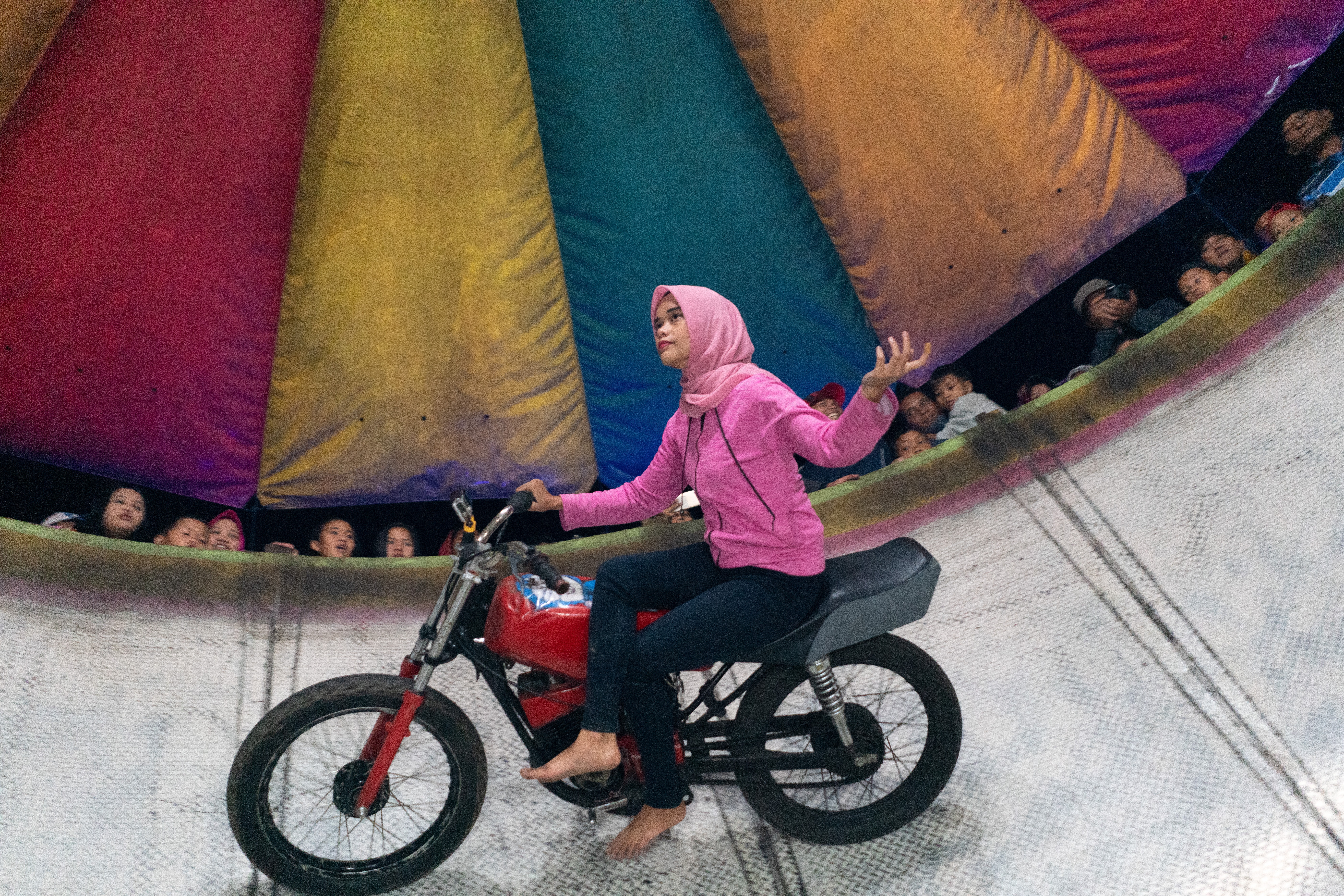 Karmila Purba stars in the Satan’s Barrel attraction of the Ikaman Enterprise travelling carnival, in Parlilitan, North Sumatra, in Indonesia. Photo: Thomas Cristofoletti / Ruom