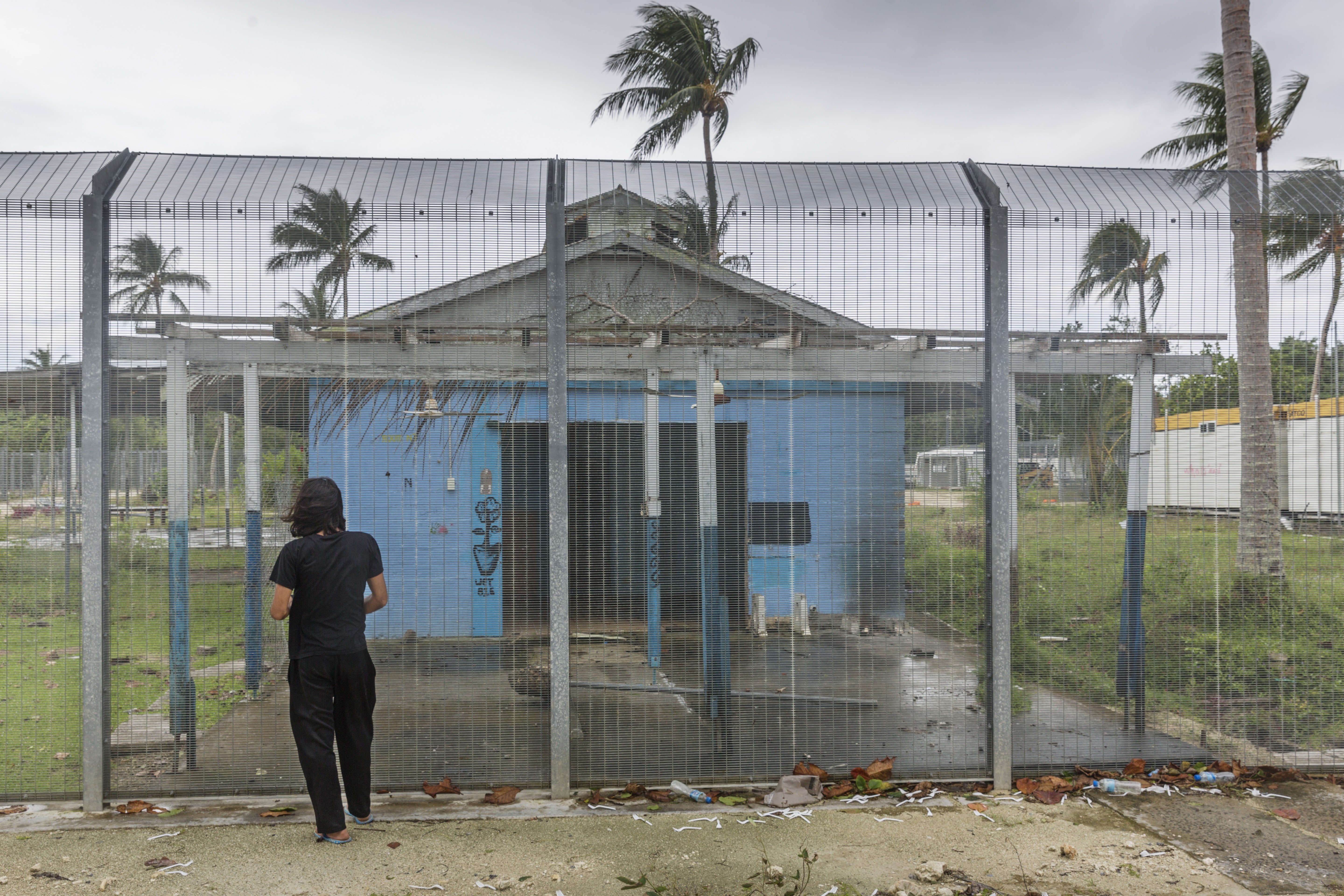 Boochani stands outside the detention centre where he was locked up for his first three years on Manus Island. Photo: Jonas Gratzer