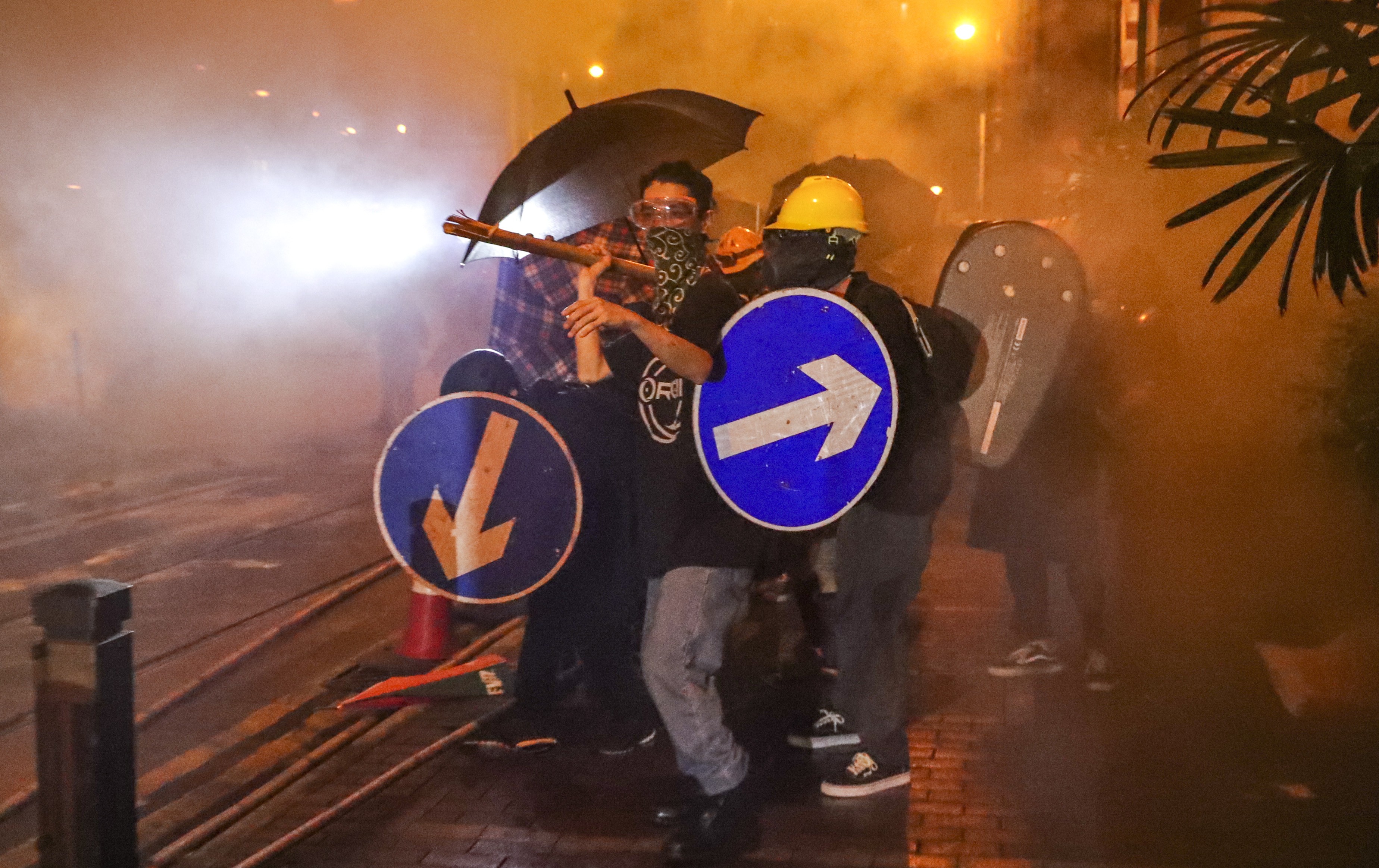 Protesters on Sunday fight through tear gas as they clash with riot police near Beijing’s liaison office in Sai Ying Pun. Photo: Edmond So