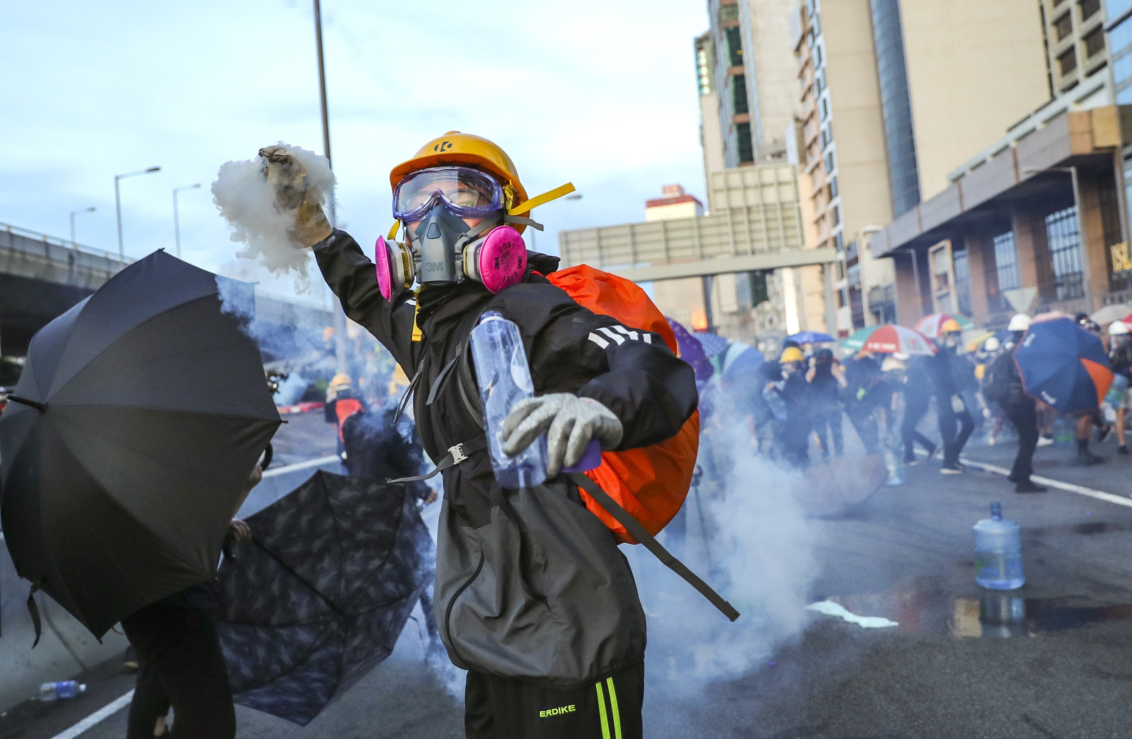 A protester throws a tear-gas canister back at riot police, as demonstrators march towards Beijing’s liaison office in Sai Ying Pun on July 28. Photo: Sam Tsang