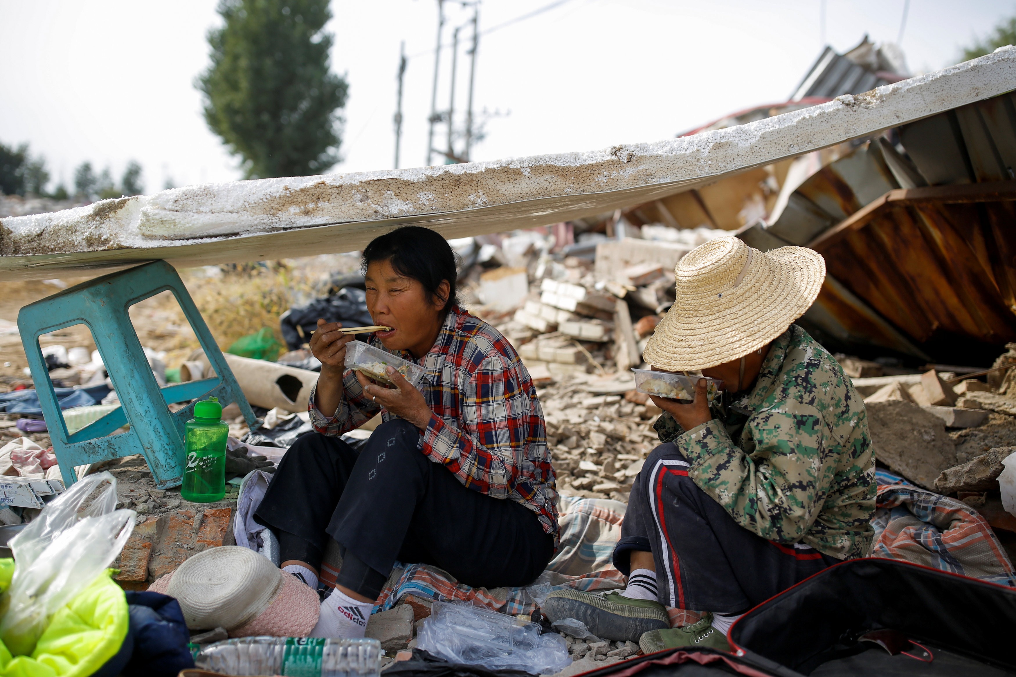 Two female migrant workers eat lunch on the outskirts of Beijing. Photo: Reuters