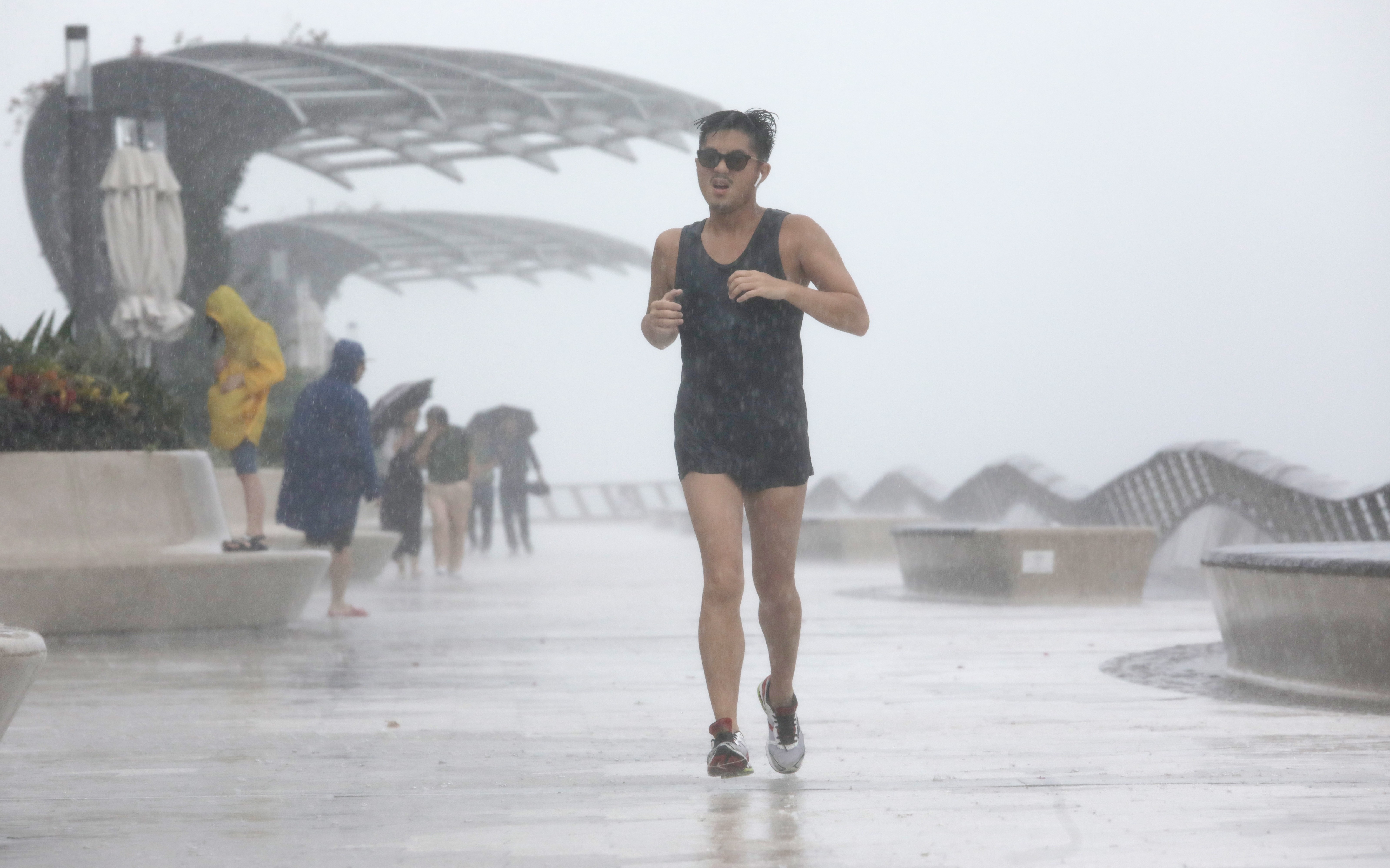 A man runs along Tsim Sha Tsui waterfront as Tropical Storm Wipha approaches Hong Kong. Photo: May Tse