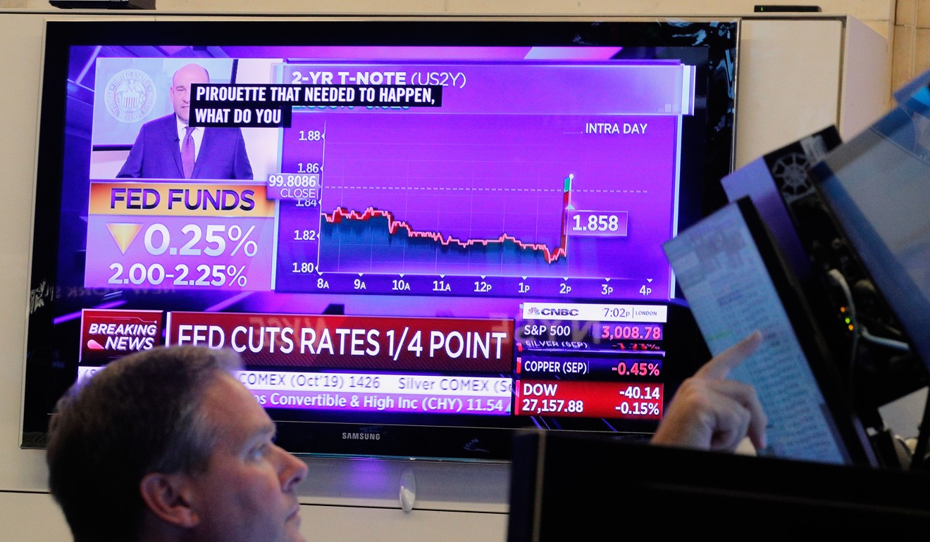 A trader looks on as a screen displays the Fed’s rate cut announcement on the floor of the New York Stock Exchange on Wednesday. Photo: Reuters