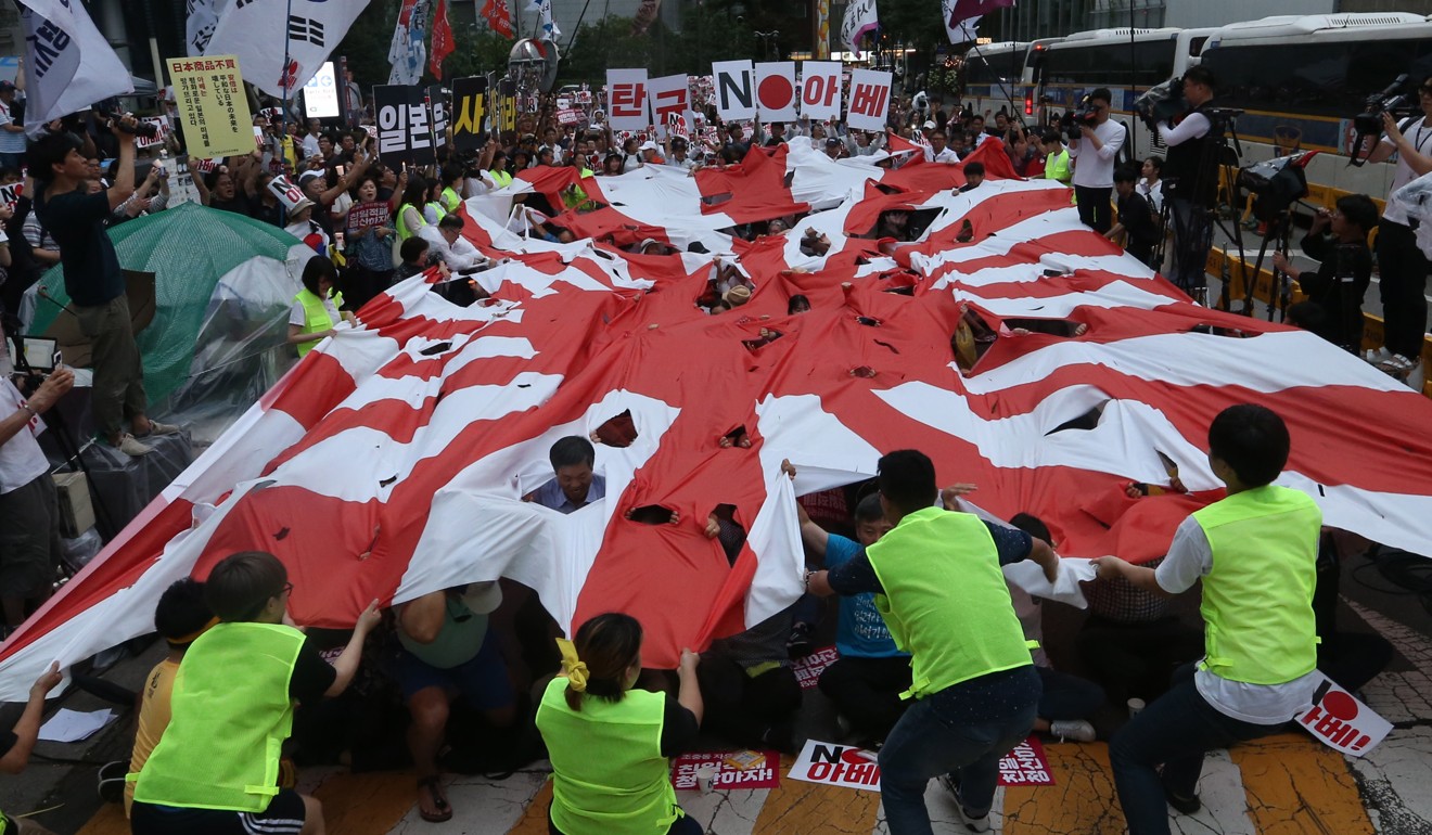 South Korean protesters tear a Japanese imperialistic flag during a rally in Seoul. Photo: EPA-EFE