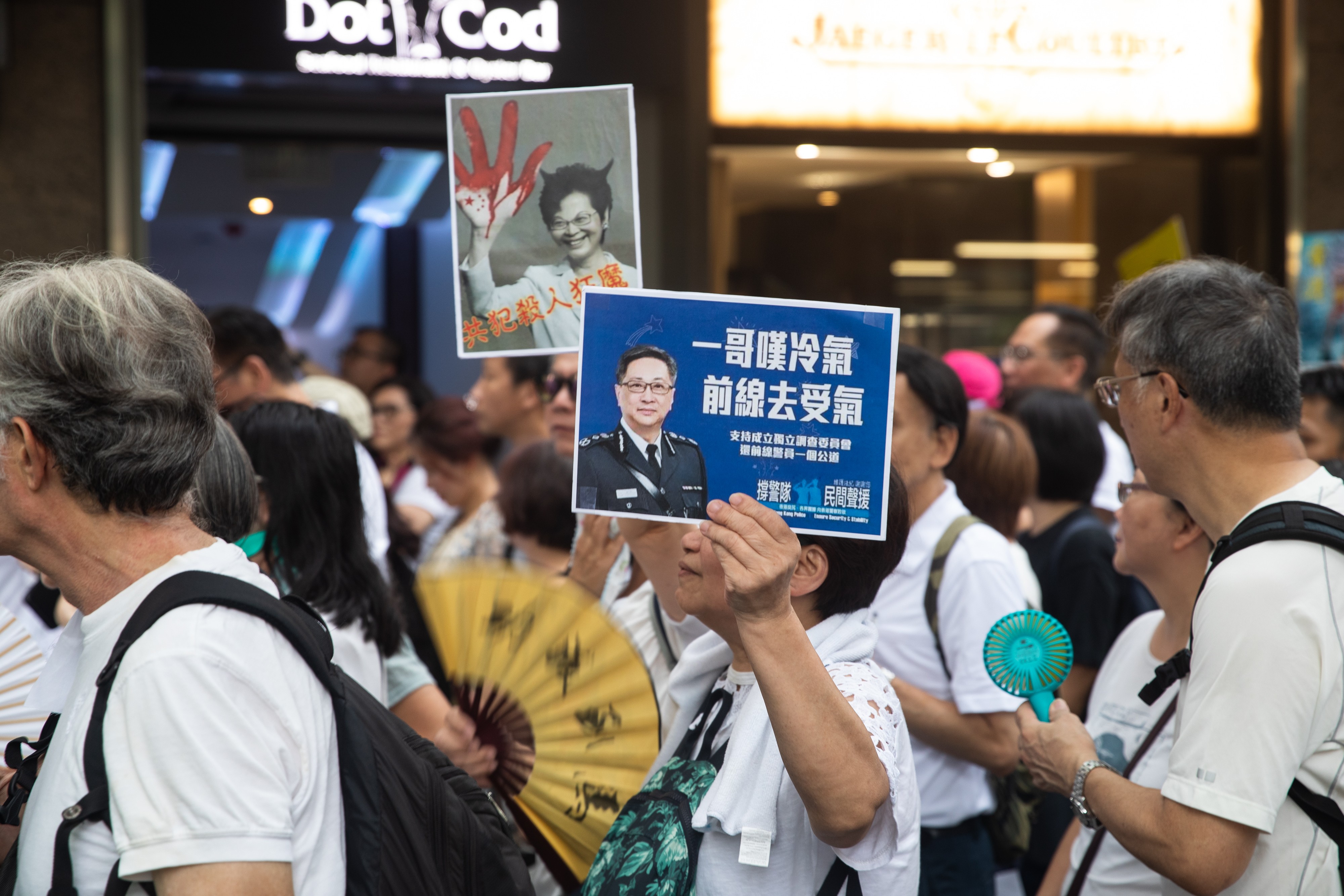Elderly demonstrators hold signs rebuking Chief Executive Carrie Lam and police chief Stephen Lo during a protest in support of young protesters on July 17. Photo: Bloomberg