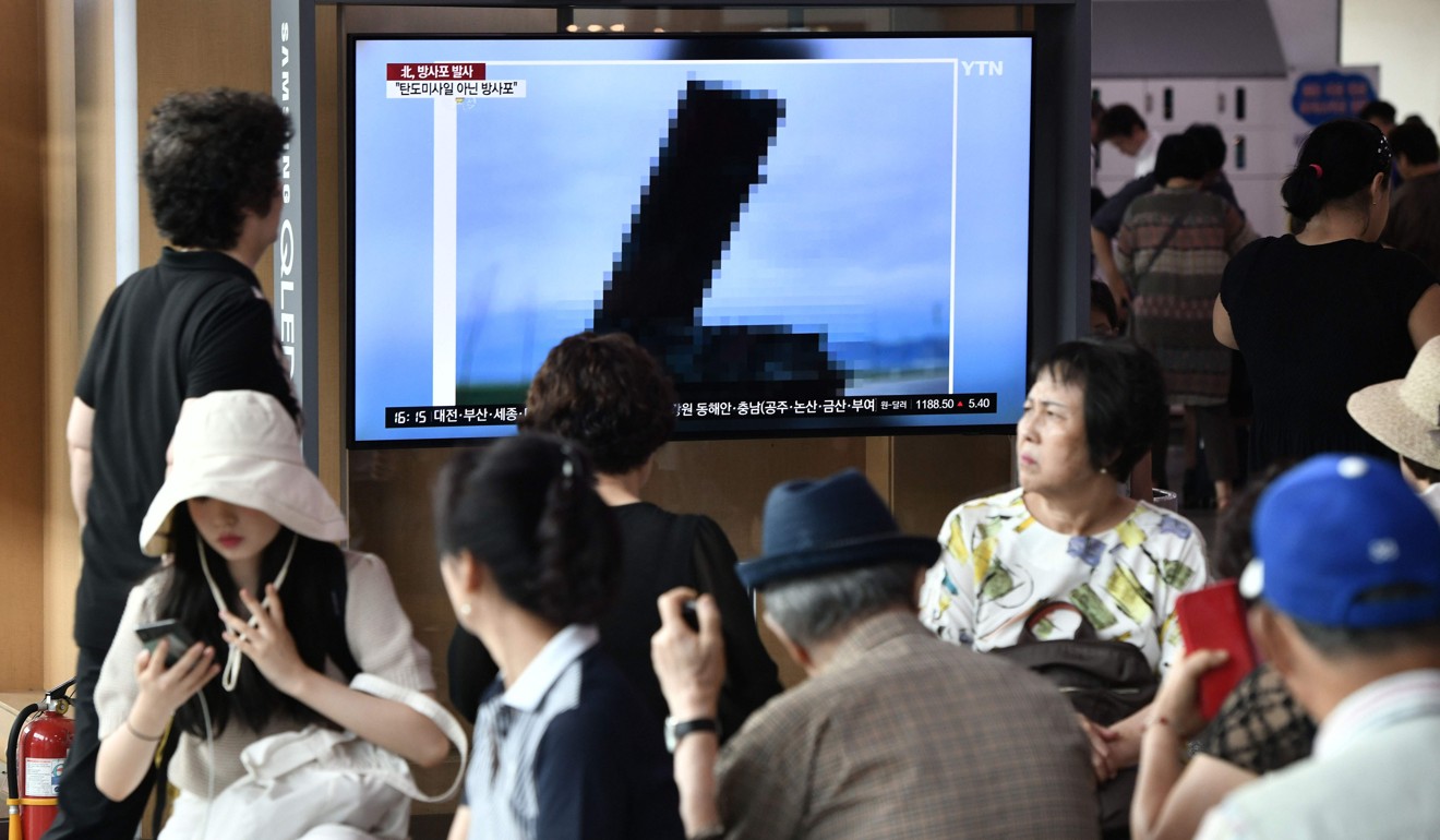 People at a railway station in Seoul on Thursday watch a television news screen showing an image of North Korea's new rocket launcher. Photo: AFP