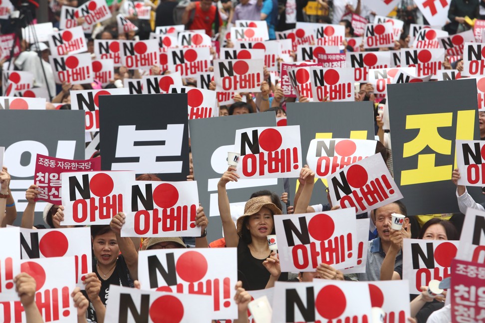 South Korean protesters hold up banners reading ‘No Abe!’. Photo: EPA-EFE