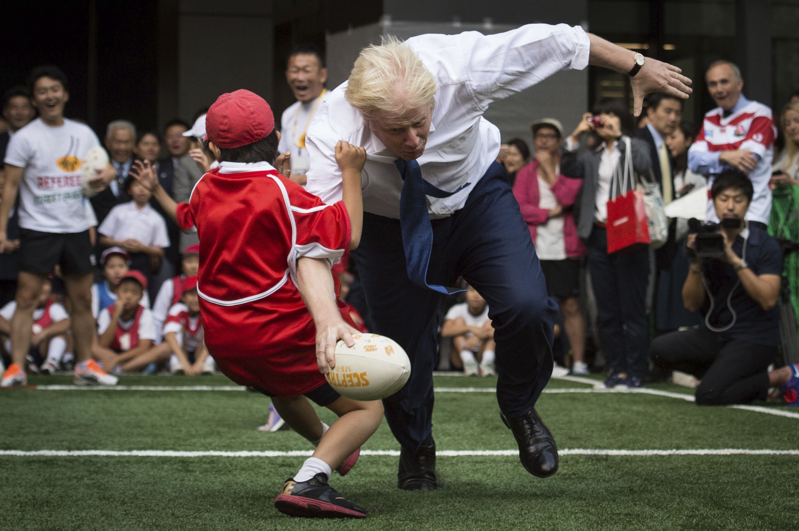 Boris Johnson knocks over a Japanese child during an exhibition rugby tournament in Tokyo. Japan has not been bowled over by Britain’s decision to exit the European Union – an idea championed by the new British prime minister. Photo: AP