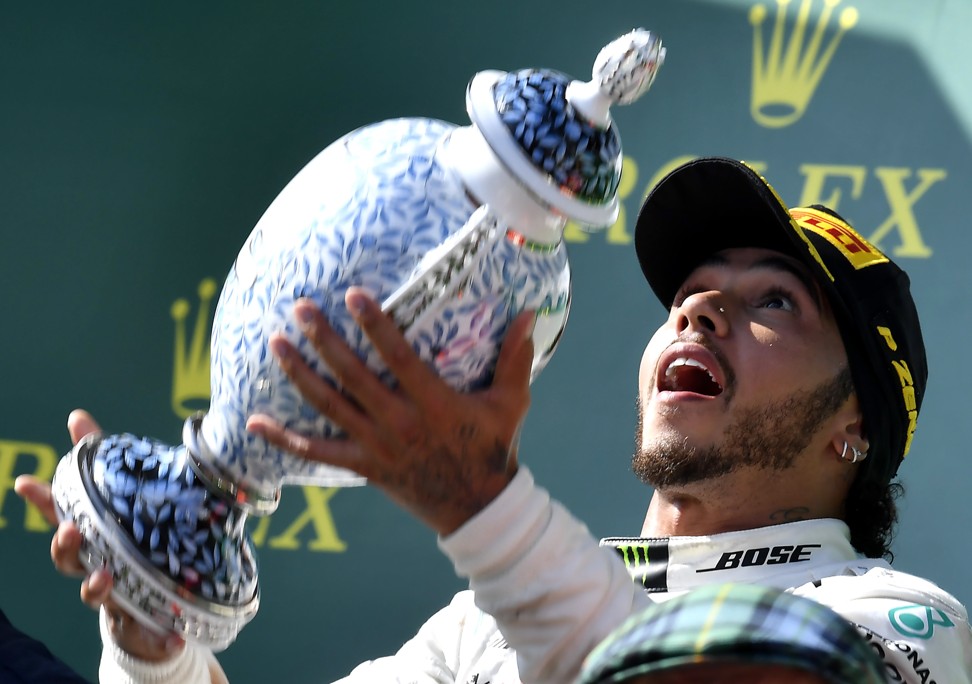 Hamilton of Mercedes celebrates with the trophy on the podium in Hungary. Photo: EPA-EFE