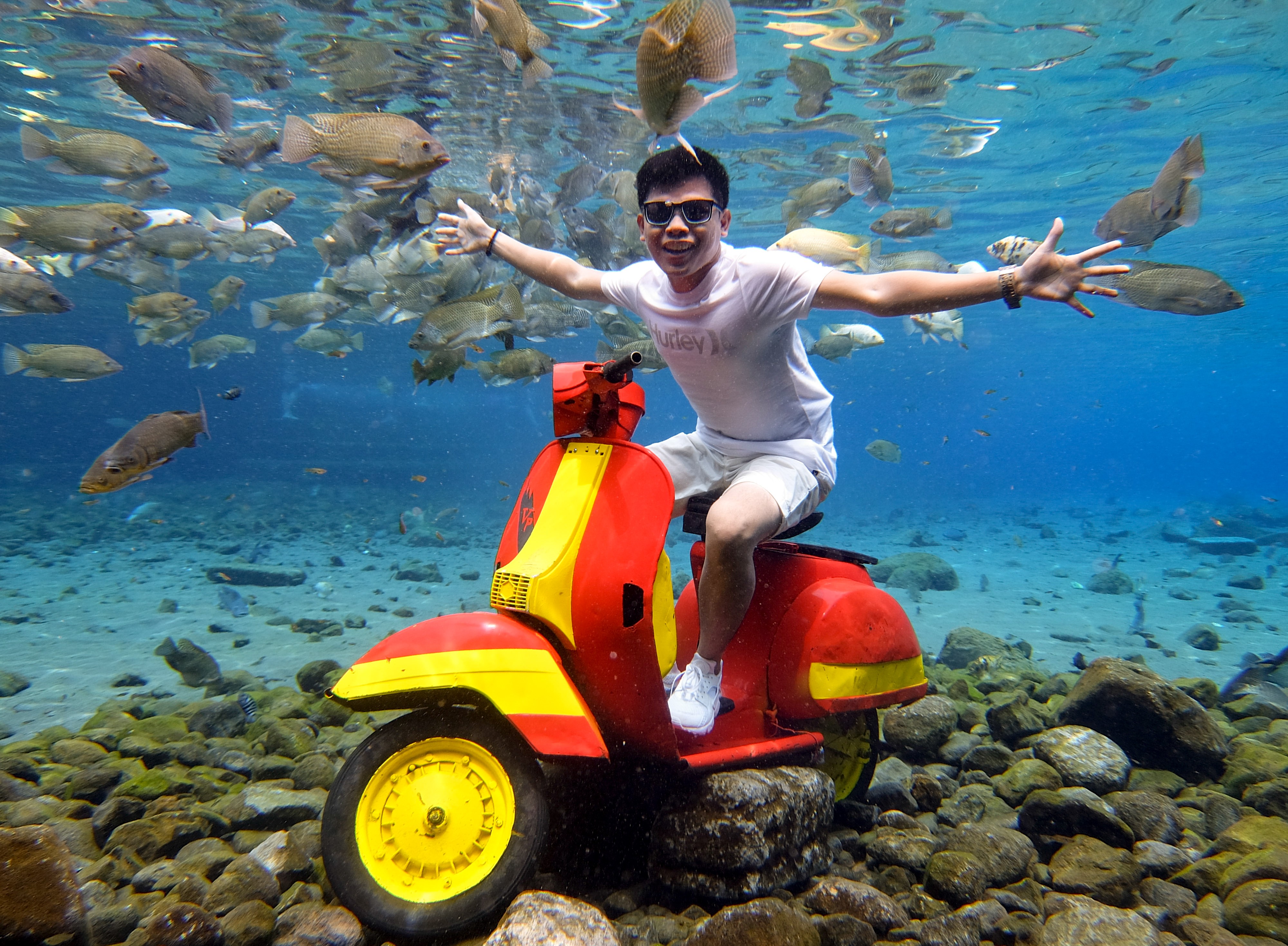 A strategically placed motorcycle is perfect for underwater poses at Umbul Ponggok, Indonesia. Photo: James Wendlinger